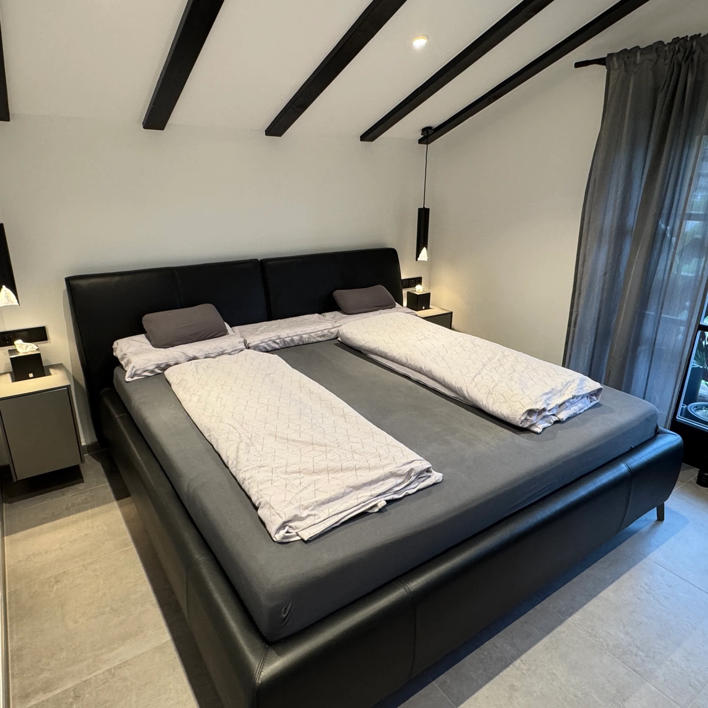 Camera da letto con un grande letto e design moderno, Nolte Living.