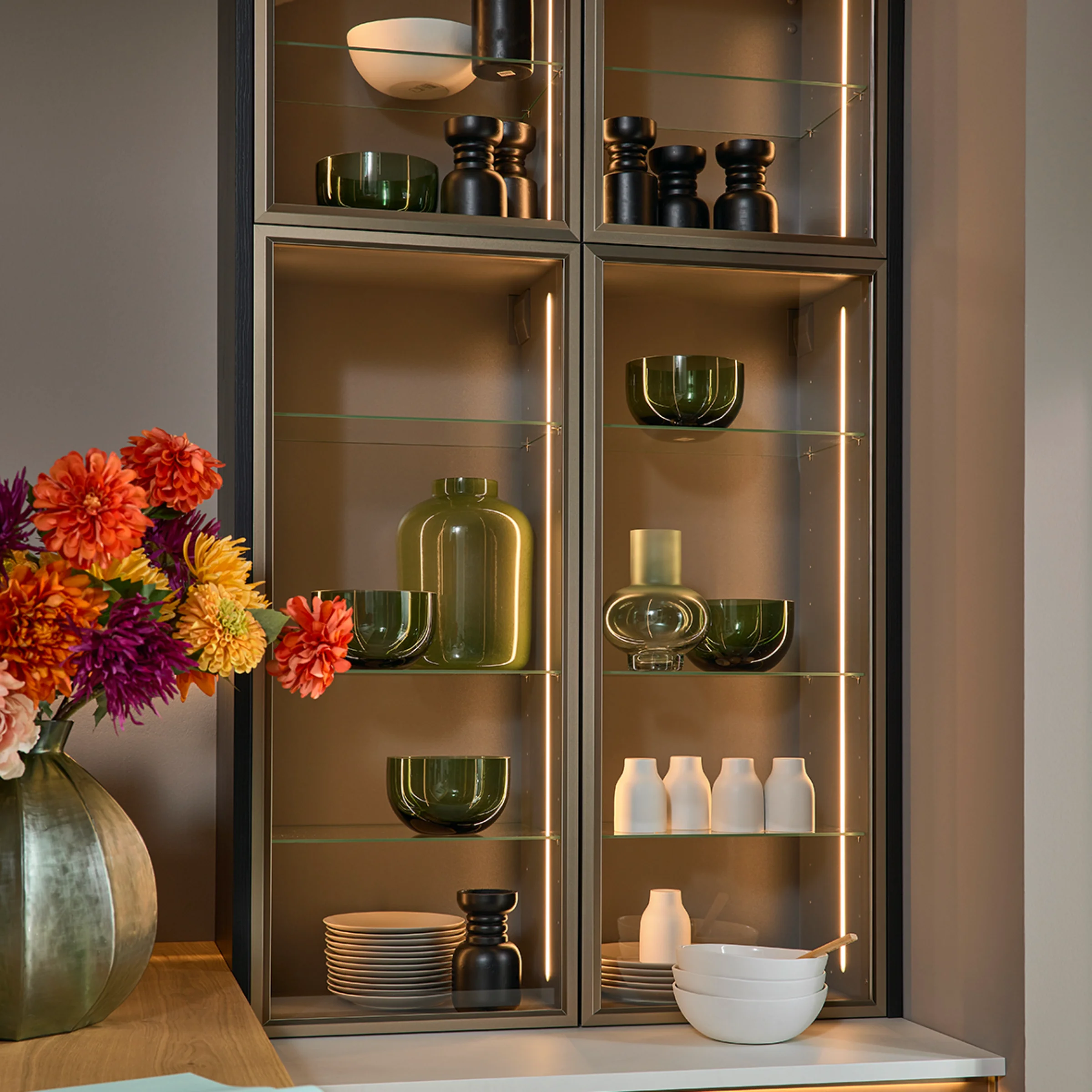 Elegante libreria da soggiorno con vasi di vetro e stoviglie, in stile Nolte Living.