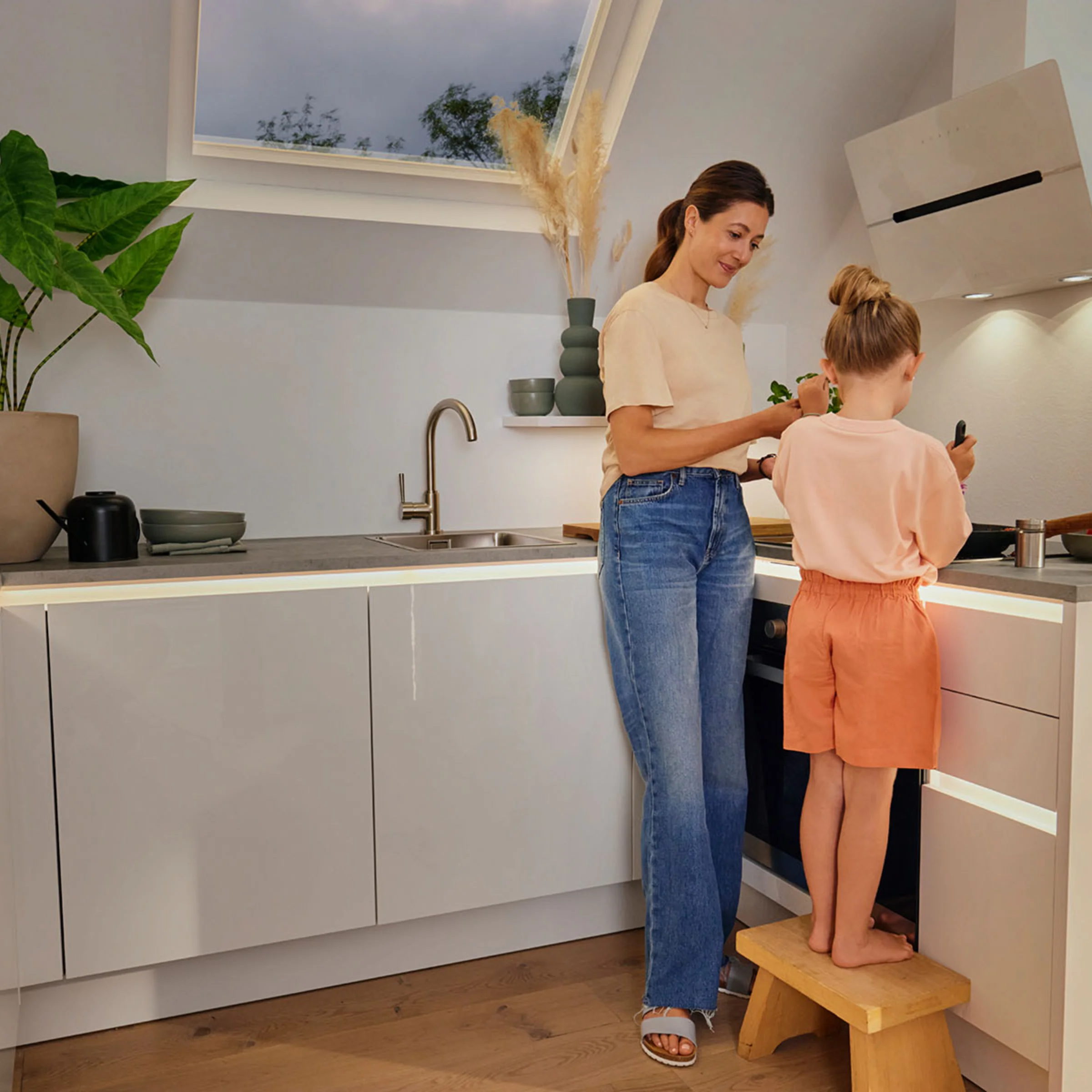 Una donna e un bambino cucinano insieme in una moderna cucina componibile Nolte.