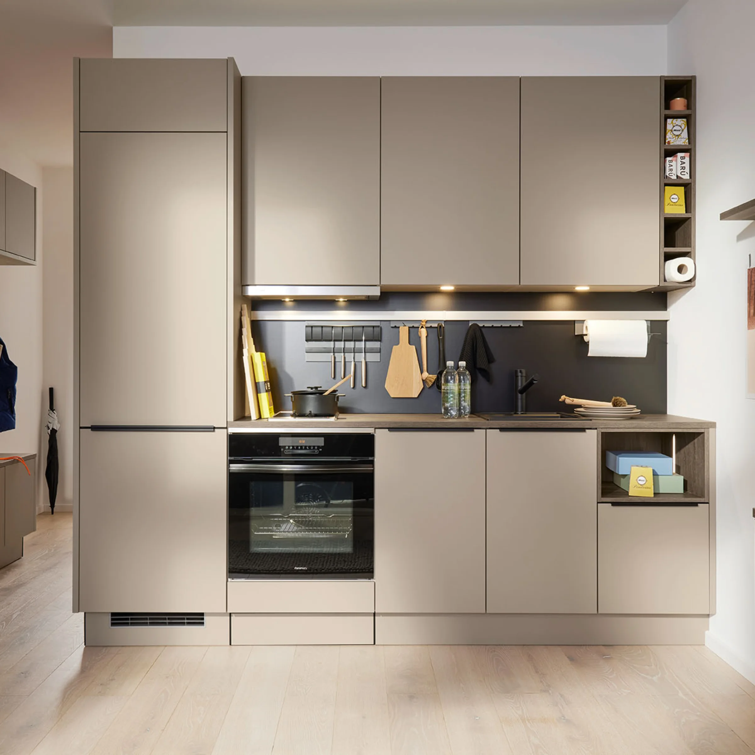 Cucina moderna con armadi beige e elettrodomestici integrati; Nolte Kitchen.