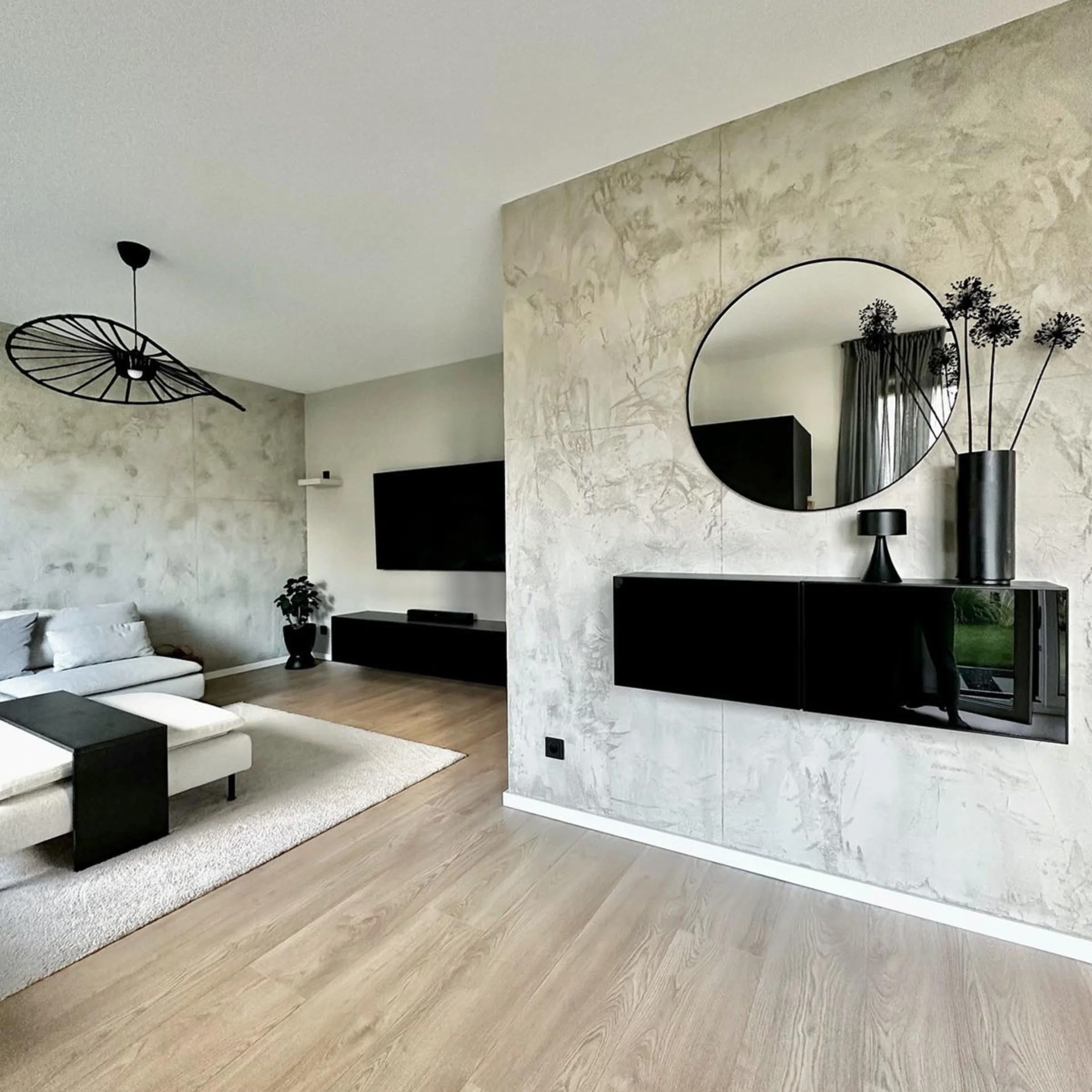 Soggiorno moderno con decorazioni nere, divano e TV, progettato da Nolte Living.