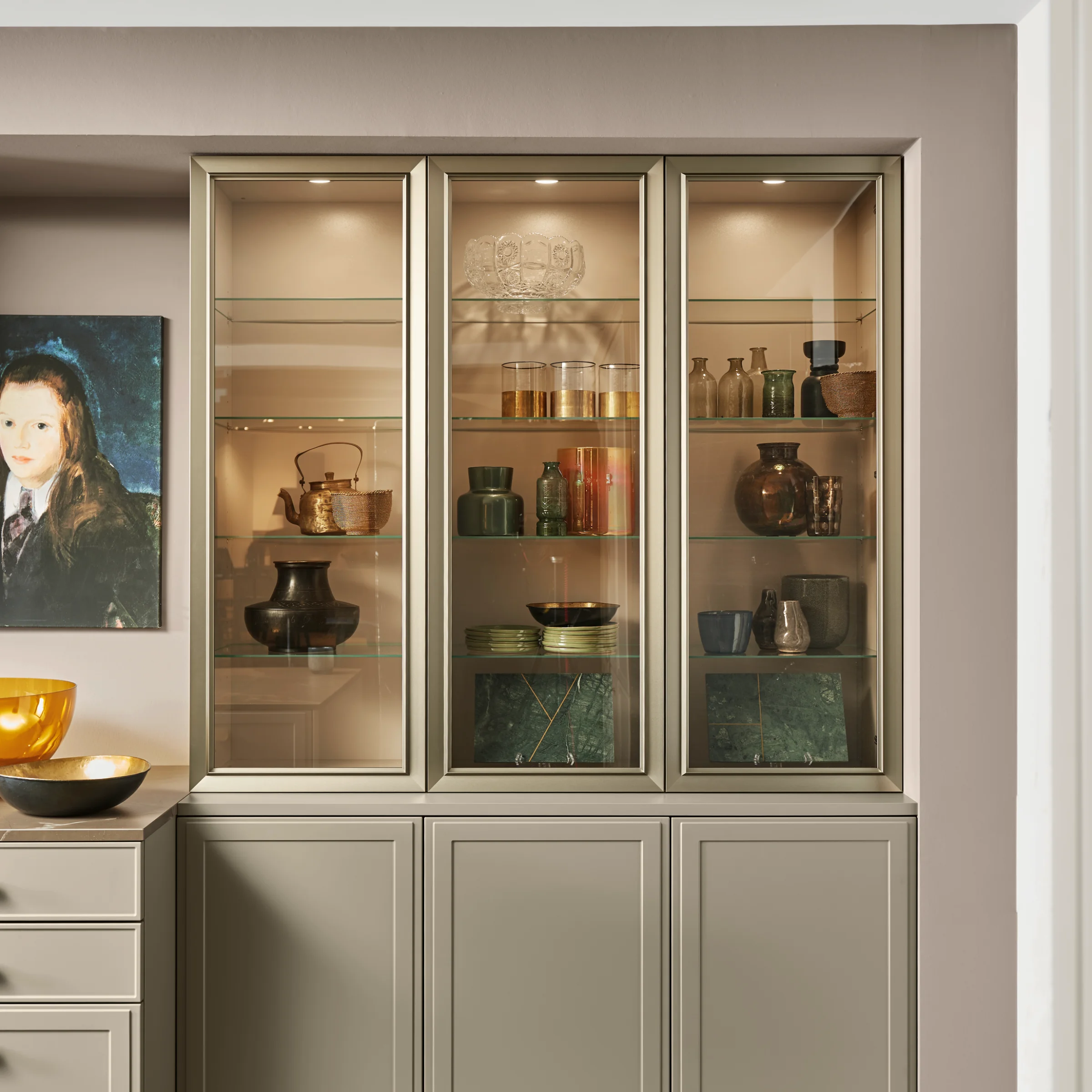 Elegante credenza con vetrina, decorata con stoviglie e arte, di Nolte Living.