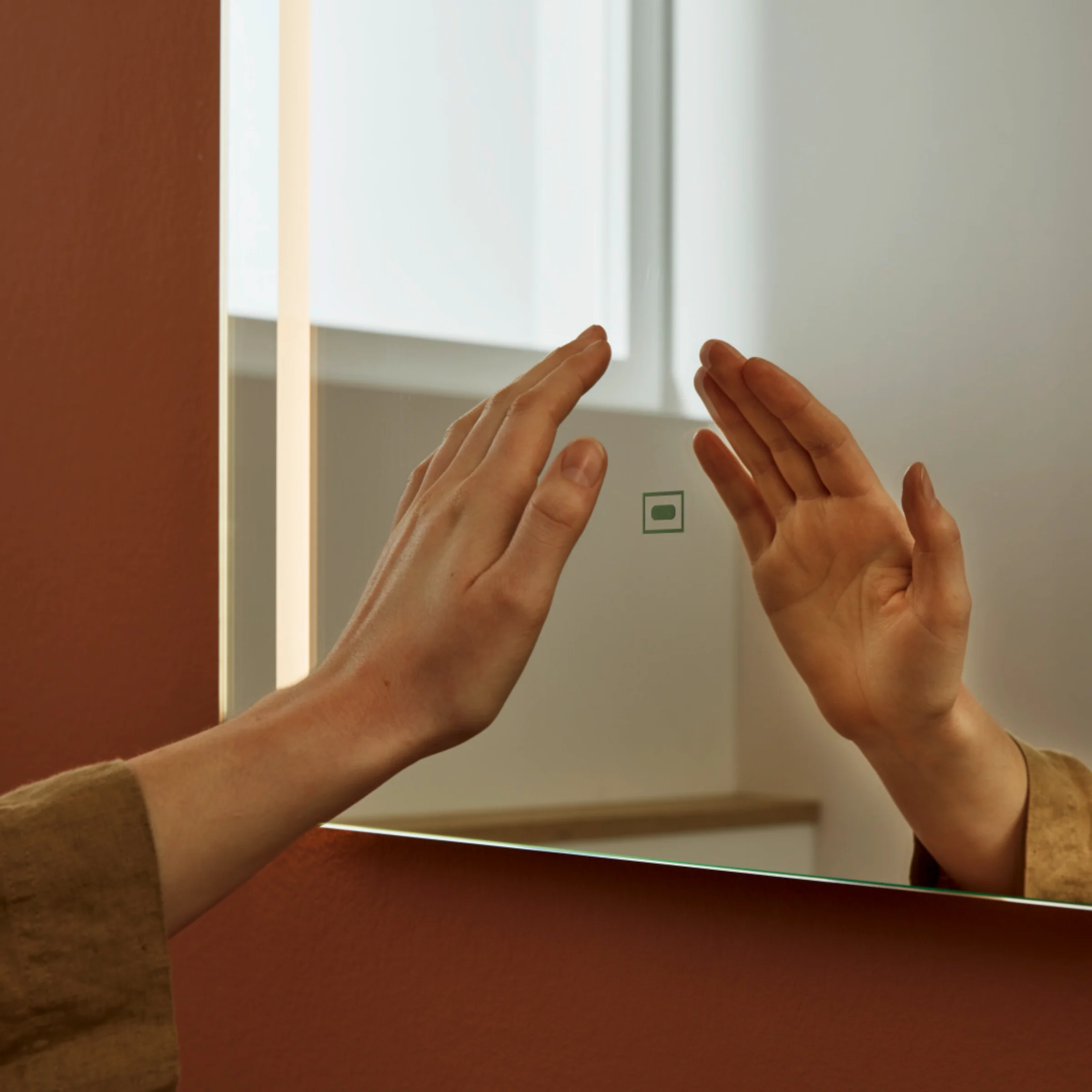 Una mano tocca uno specchio illuminato in un elegante bagno Nolte SPA.
