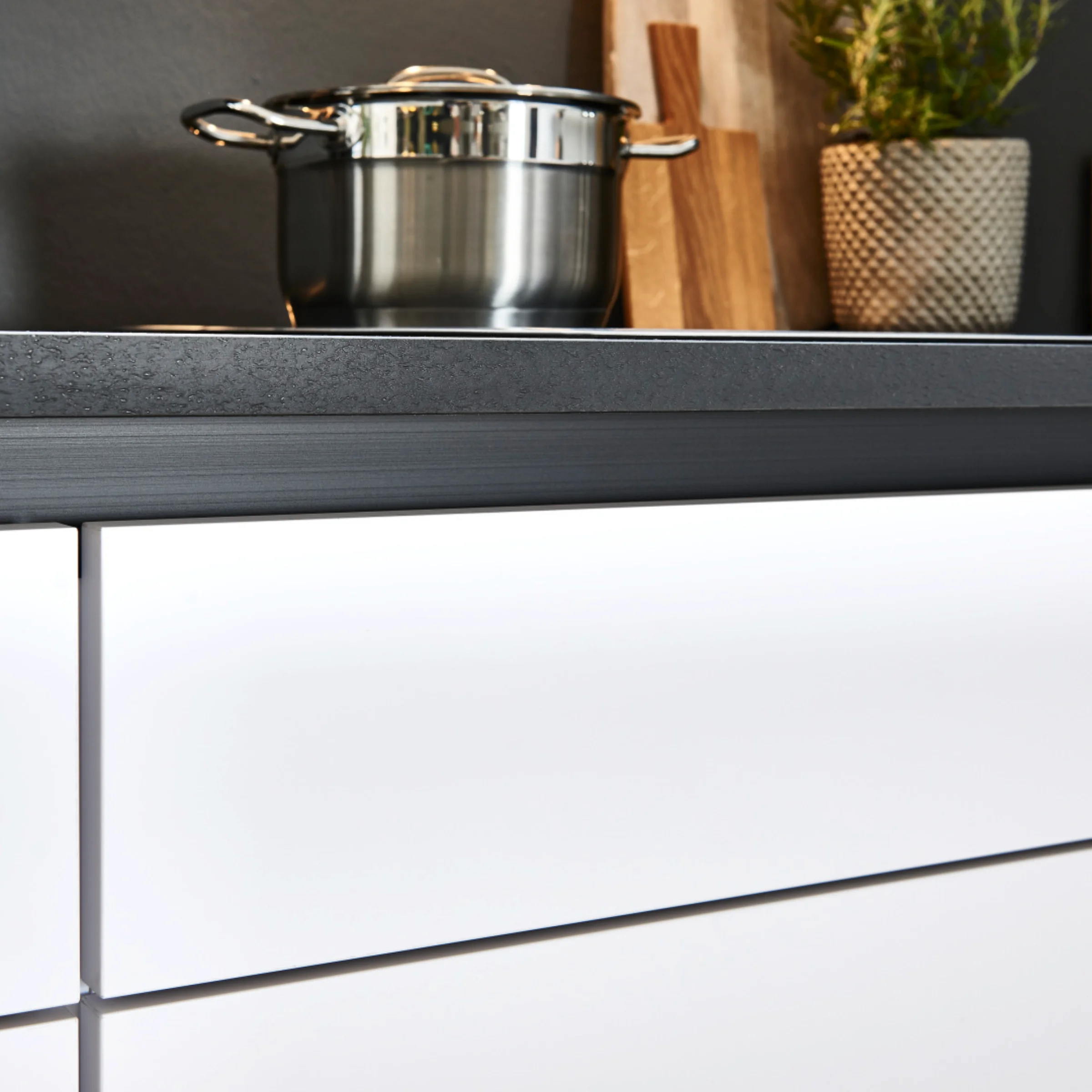 Cucina moderna con pentola e tagliere sul piano di lavoro, integrata in Nolte Kitchen.
