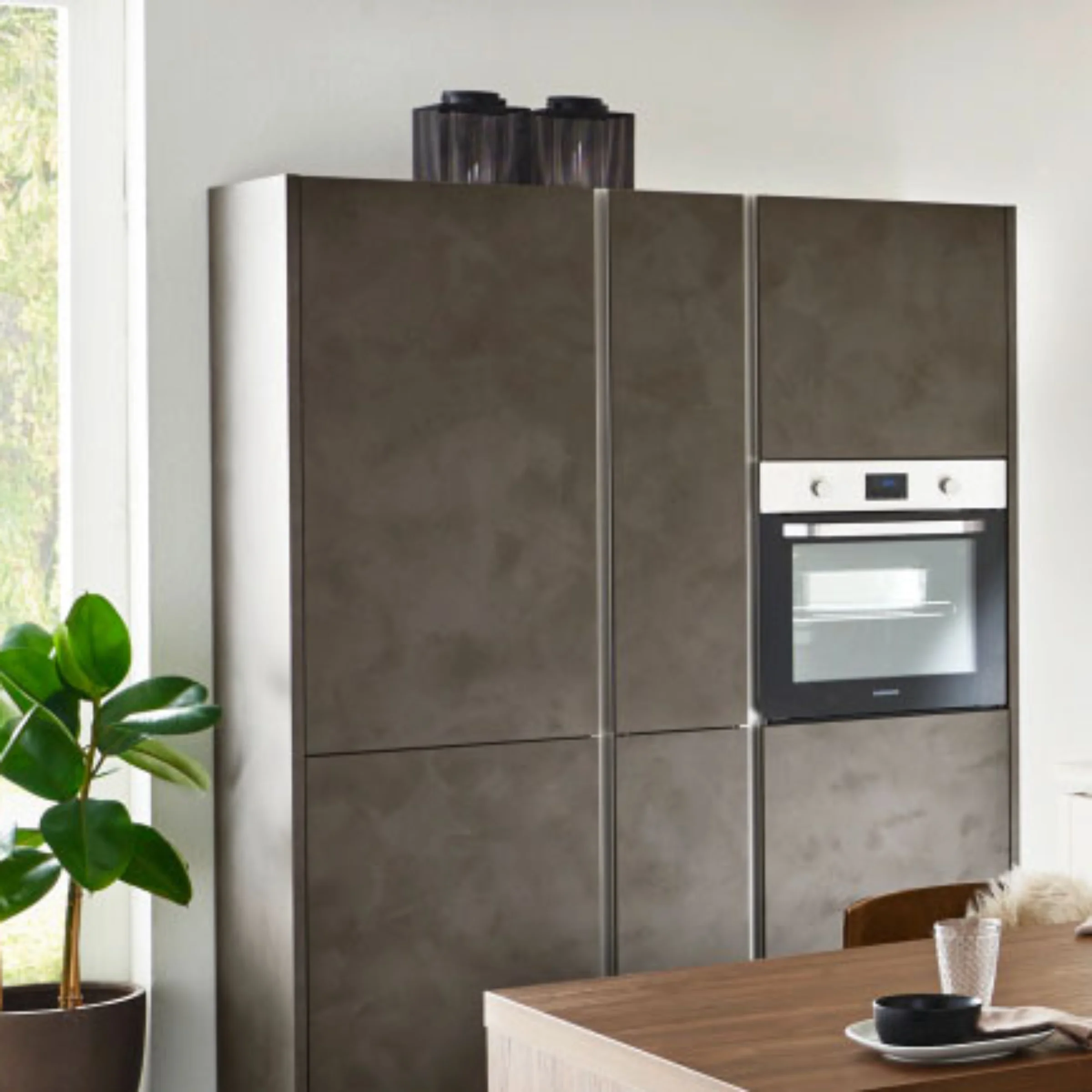 Cucina moderna con armadi grigi e forno integrato di Nolte Kitchen.