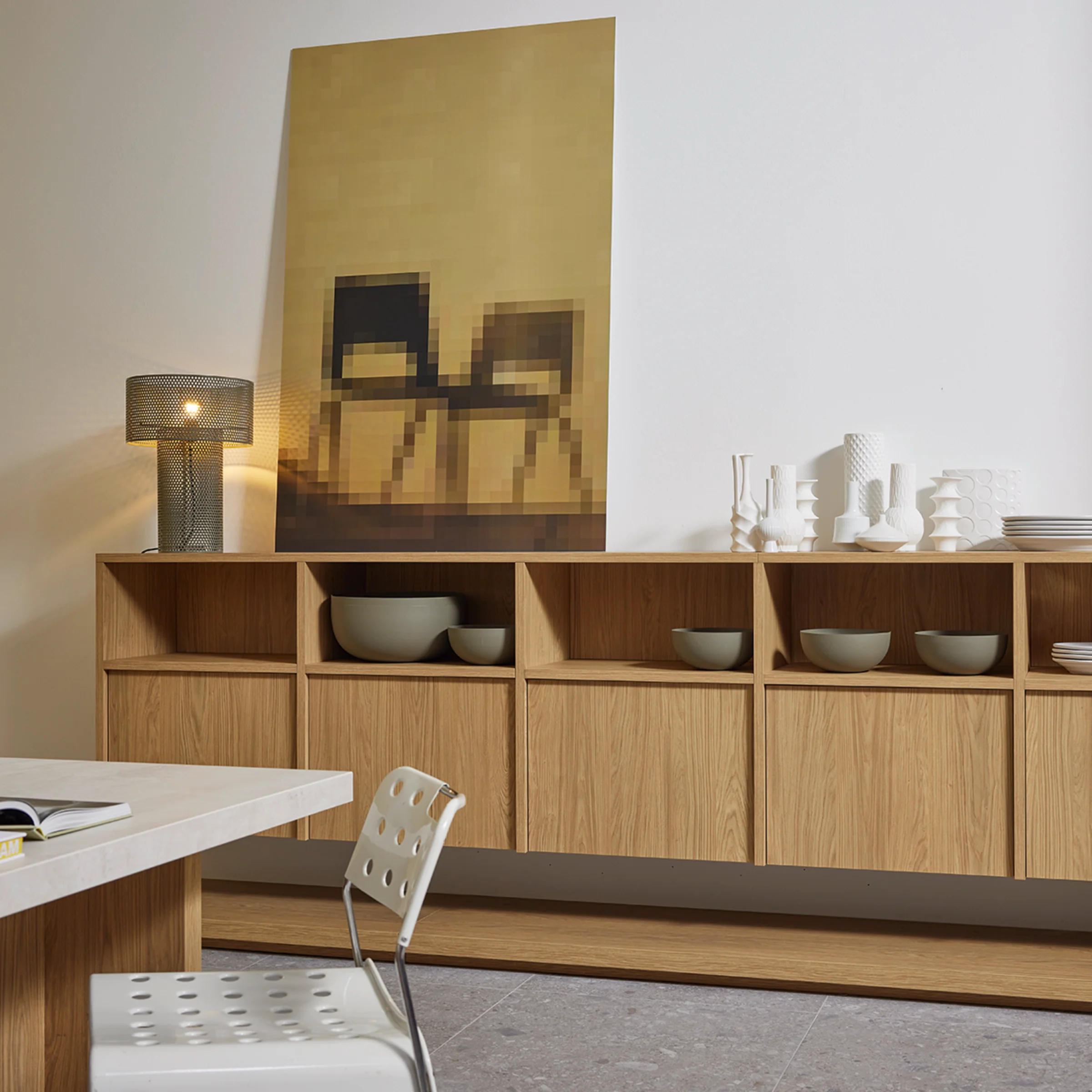 Soggiorno moderno con scaffali in legno e decorazioni, presentato da Nolte Living.