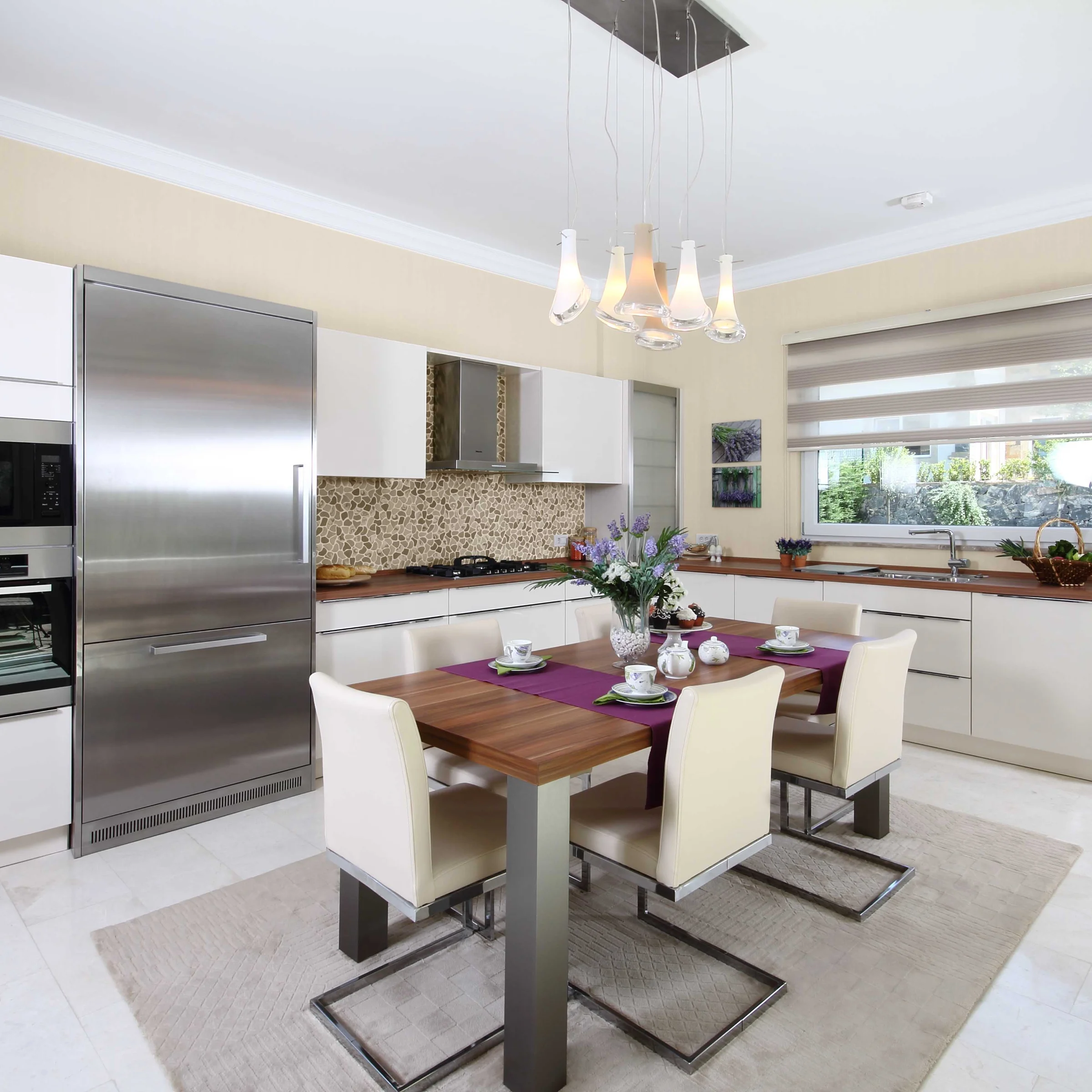 Cucina moderna con tavolo da pranzo, sedie ed elettrodomestici integrati. Nolte Kitchen.