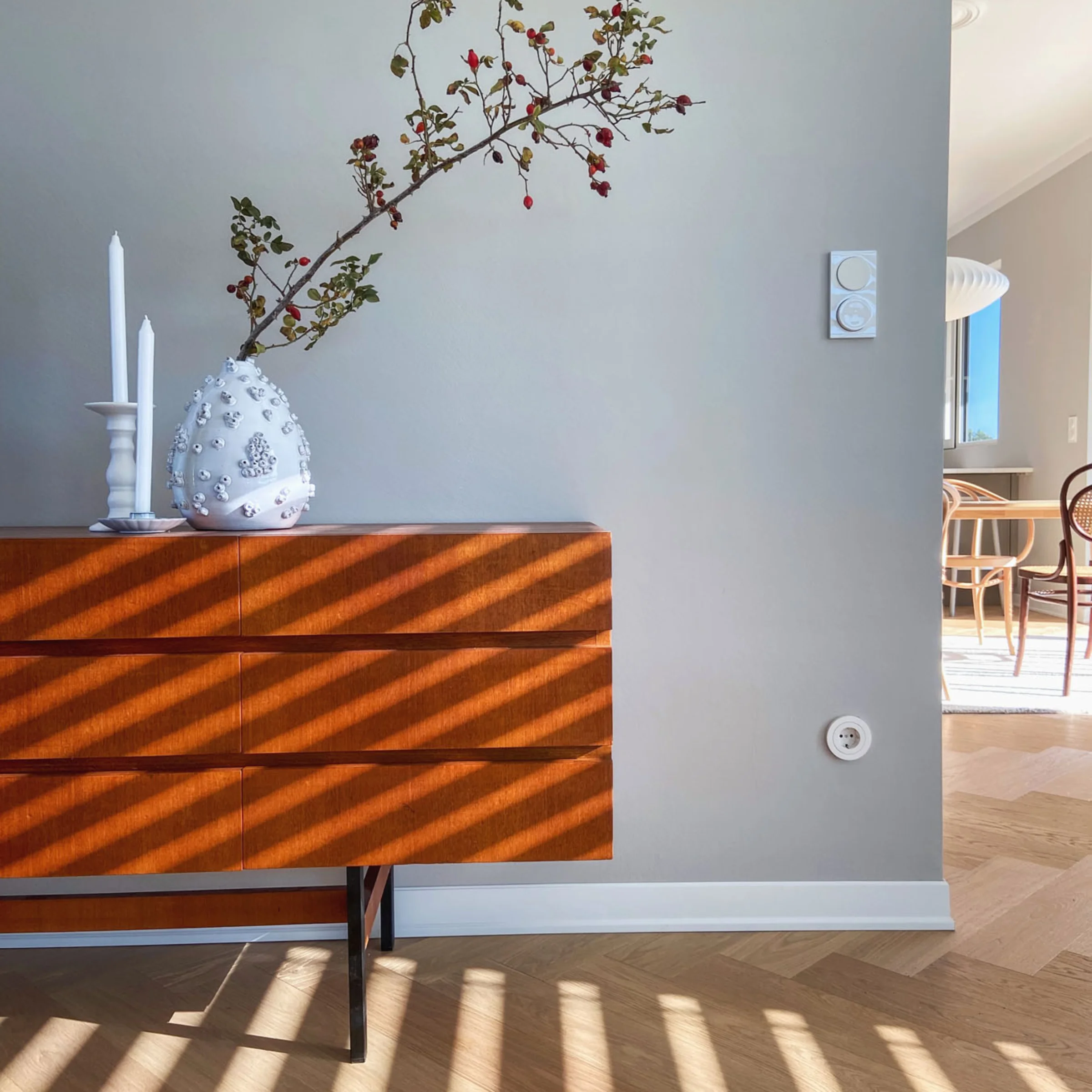 Credenza con vaso e candele in una stanza luminosa, Nolte Living.