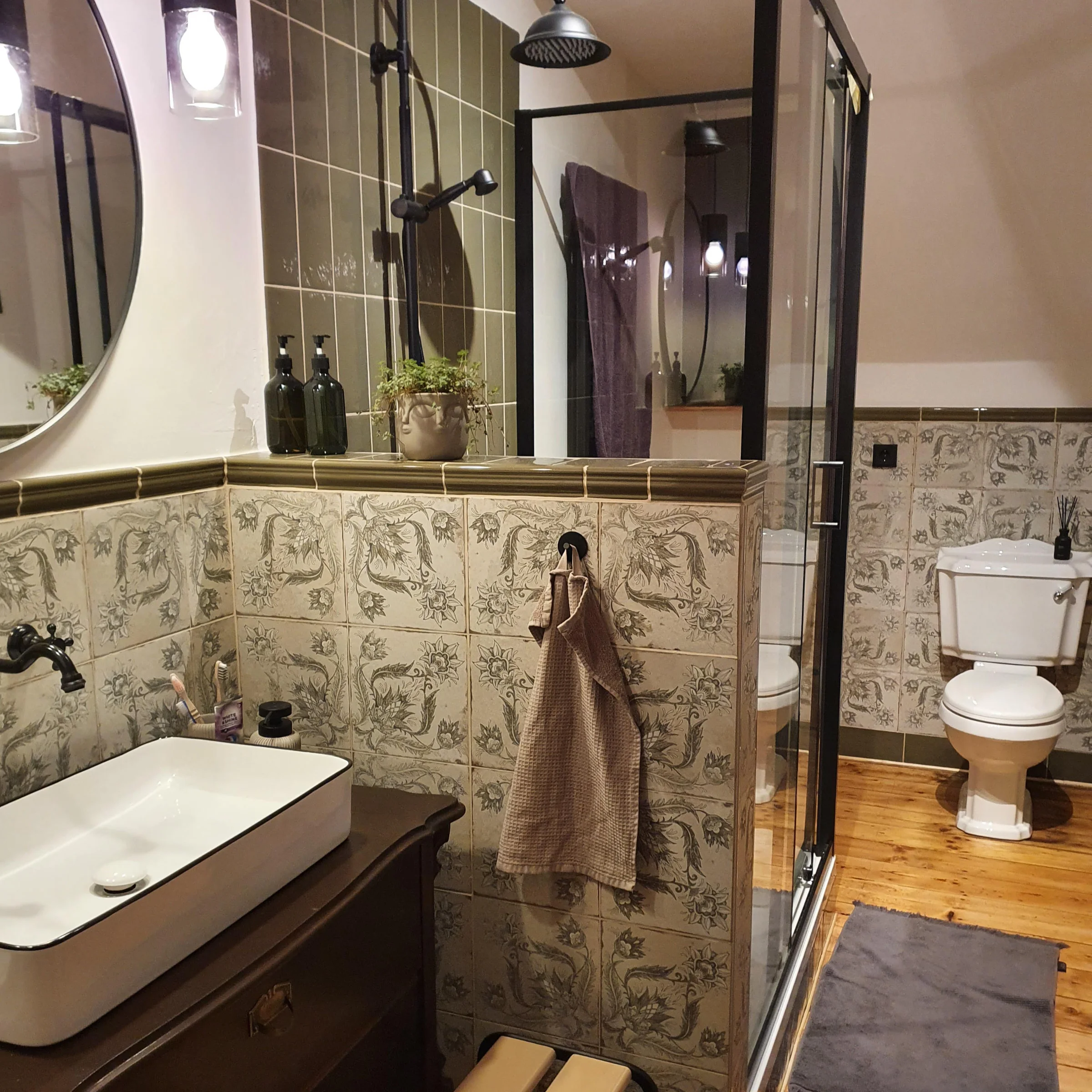 Elegante bagno con doccia e lavabo, decorato con piante e piastrelle. Nolte SPA.