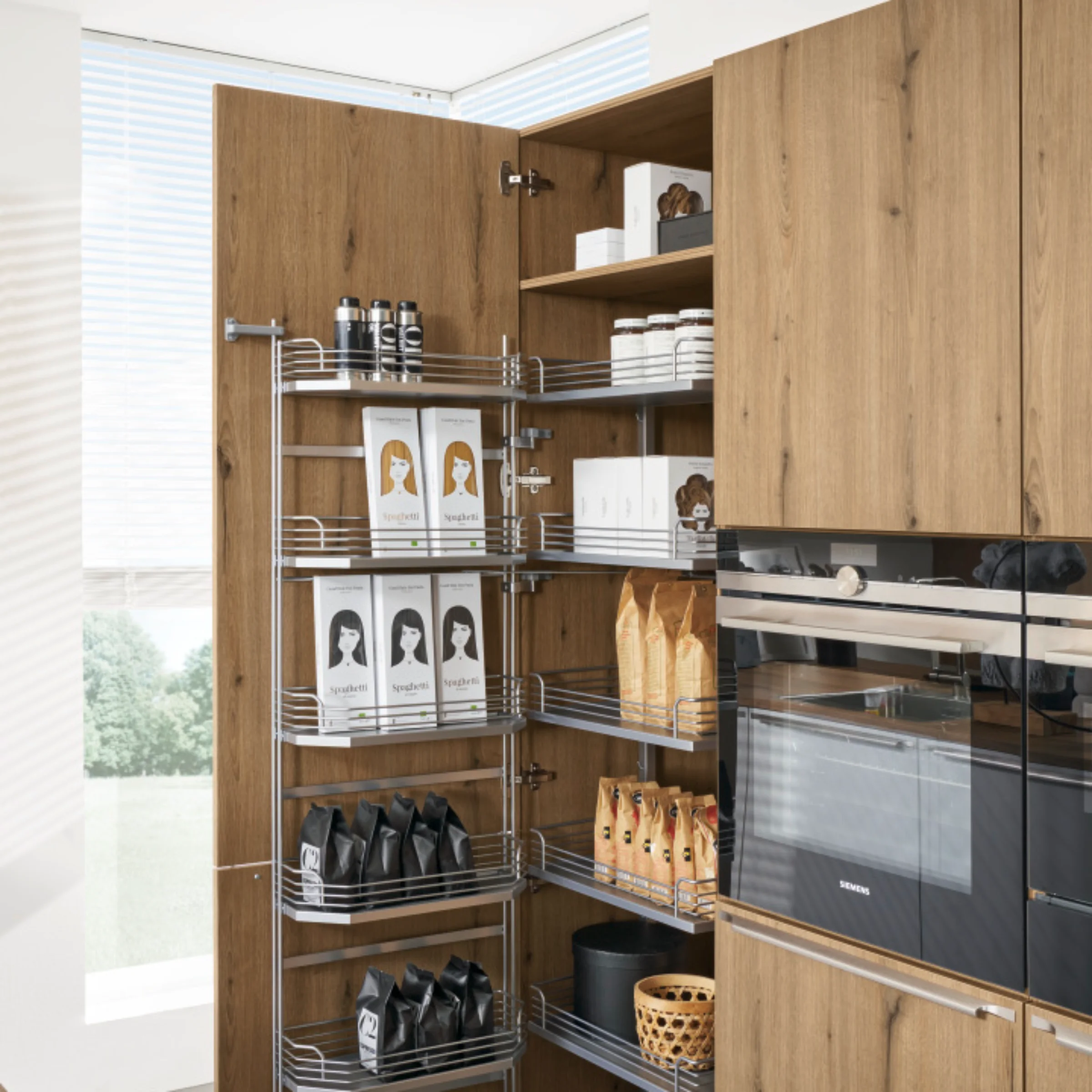 Un armadietto da cucina aperto con scorte e finitura in legno di Nolte Kitchen.