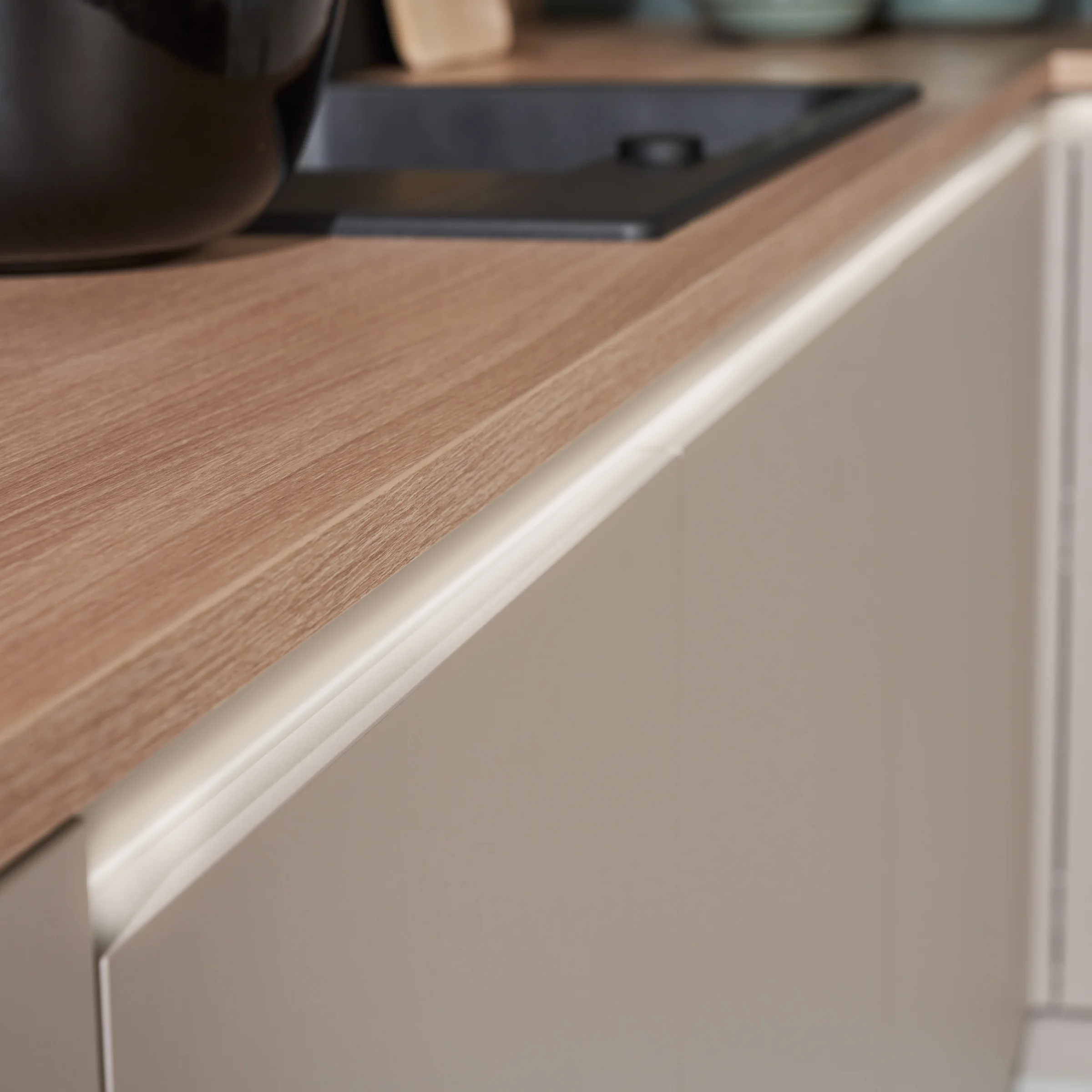 Cucina moderna con piano in legno e mobili chiari di Nolte Kitchen.