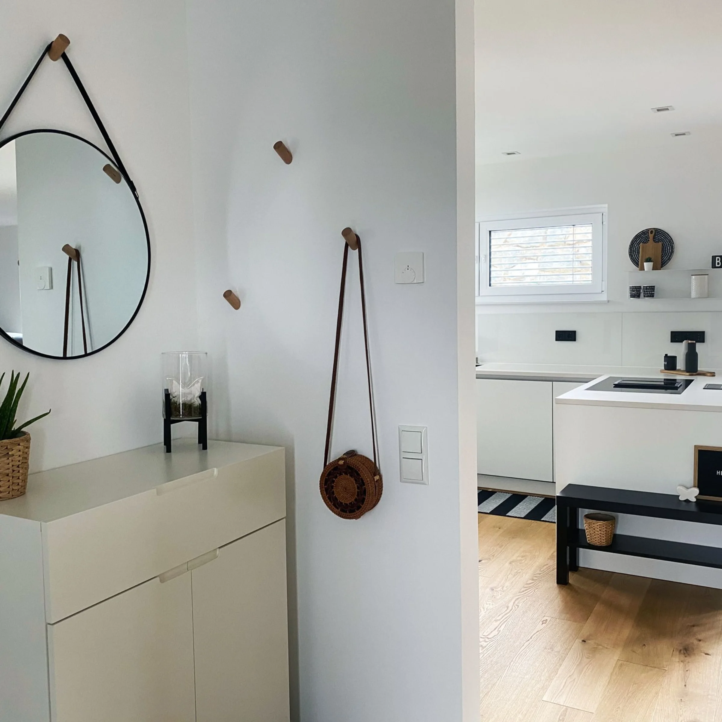 Cucina moderna con armadi bianchi e dettagli in legno, arredata da Nolte Kitchen.
