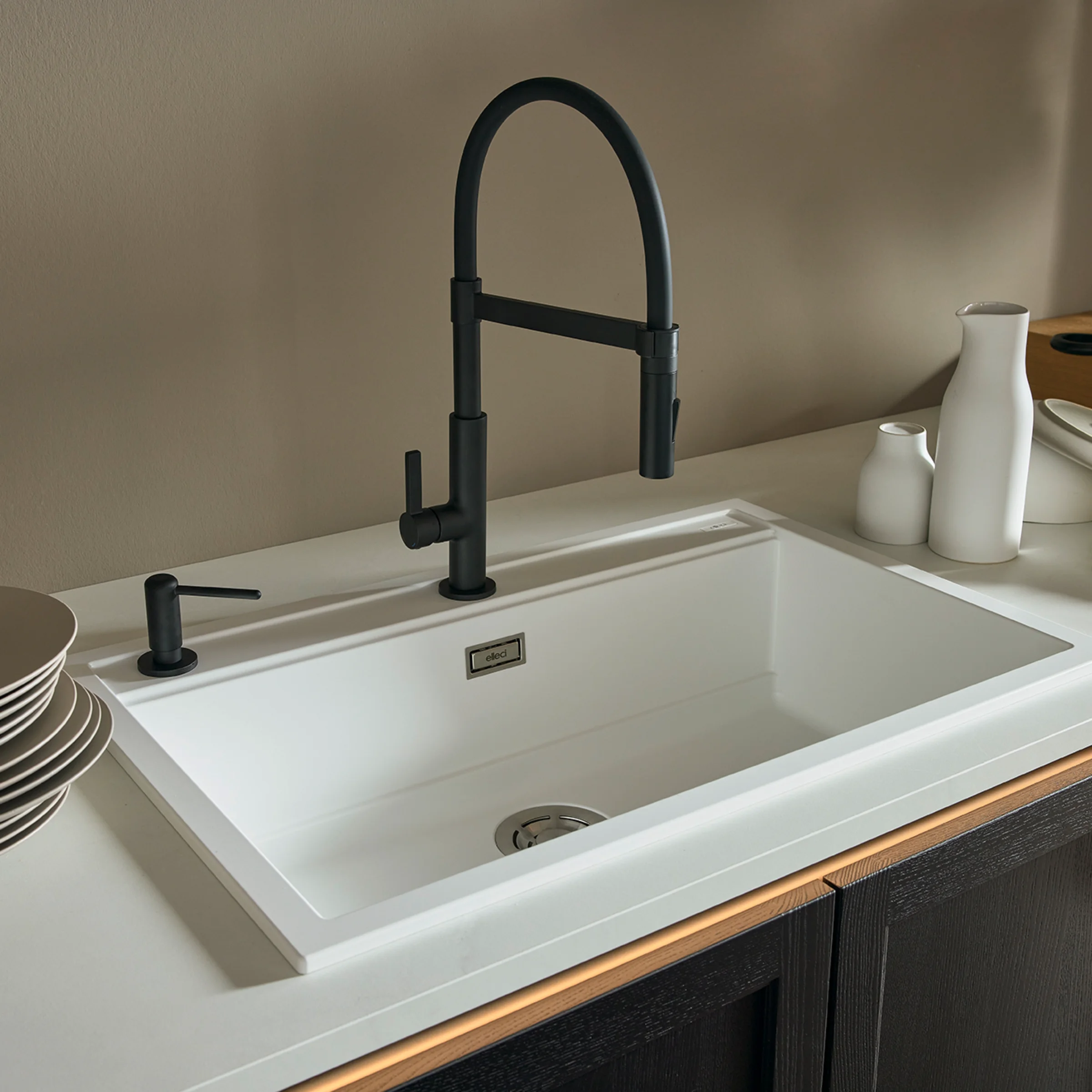 Cucina moderna con lavello bianco e rubinetto nero di Nolte Kitchen.