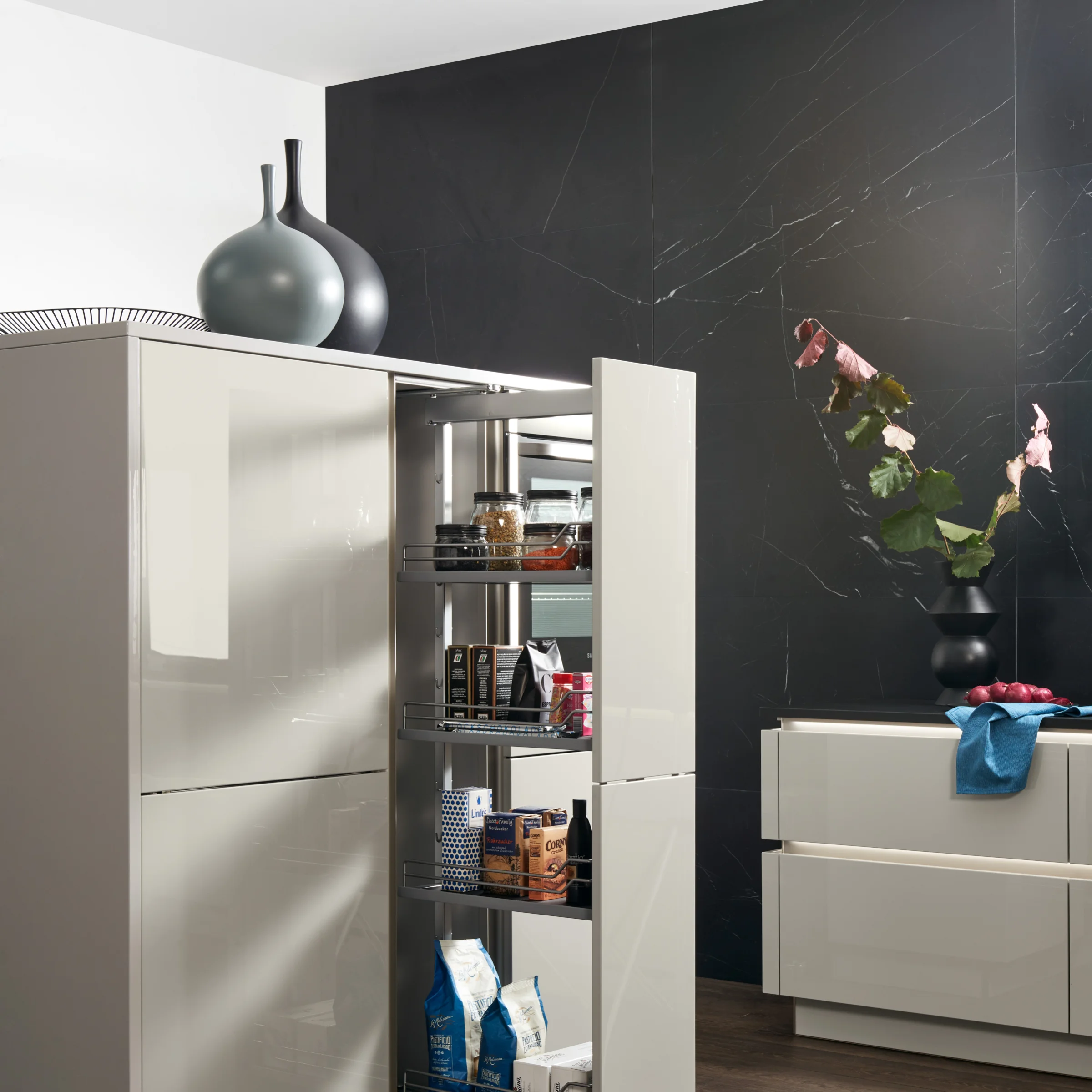 Cucina moderna con armadi lucidi e scaffale dispensa di Nolte Kitchen.