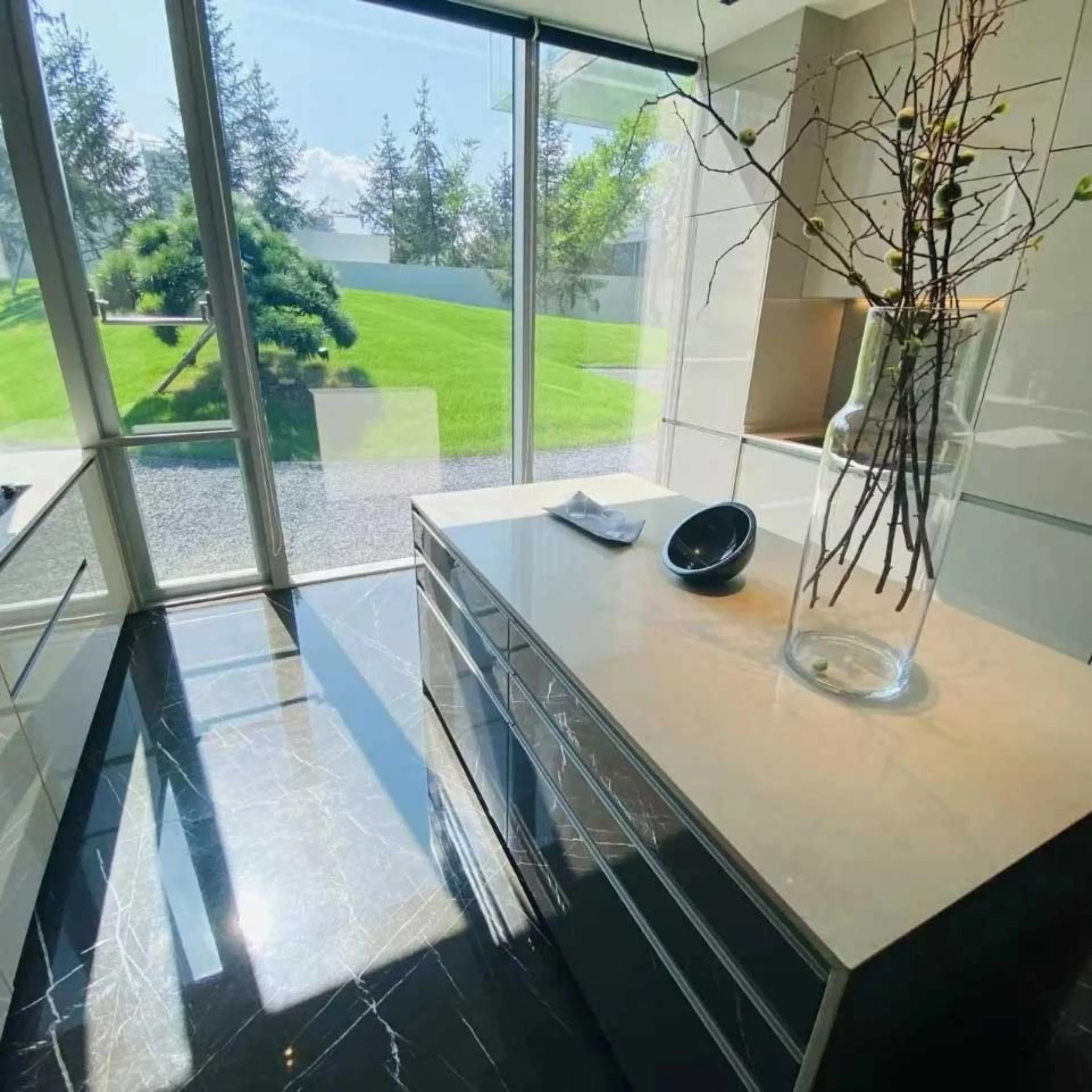 Una cucina moderna con grandi finestre e un'isola centrale, progettata da Nolte Kitchen.