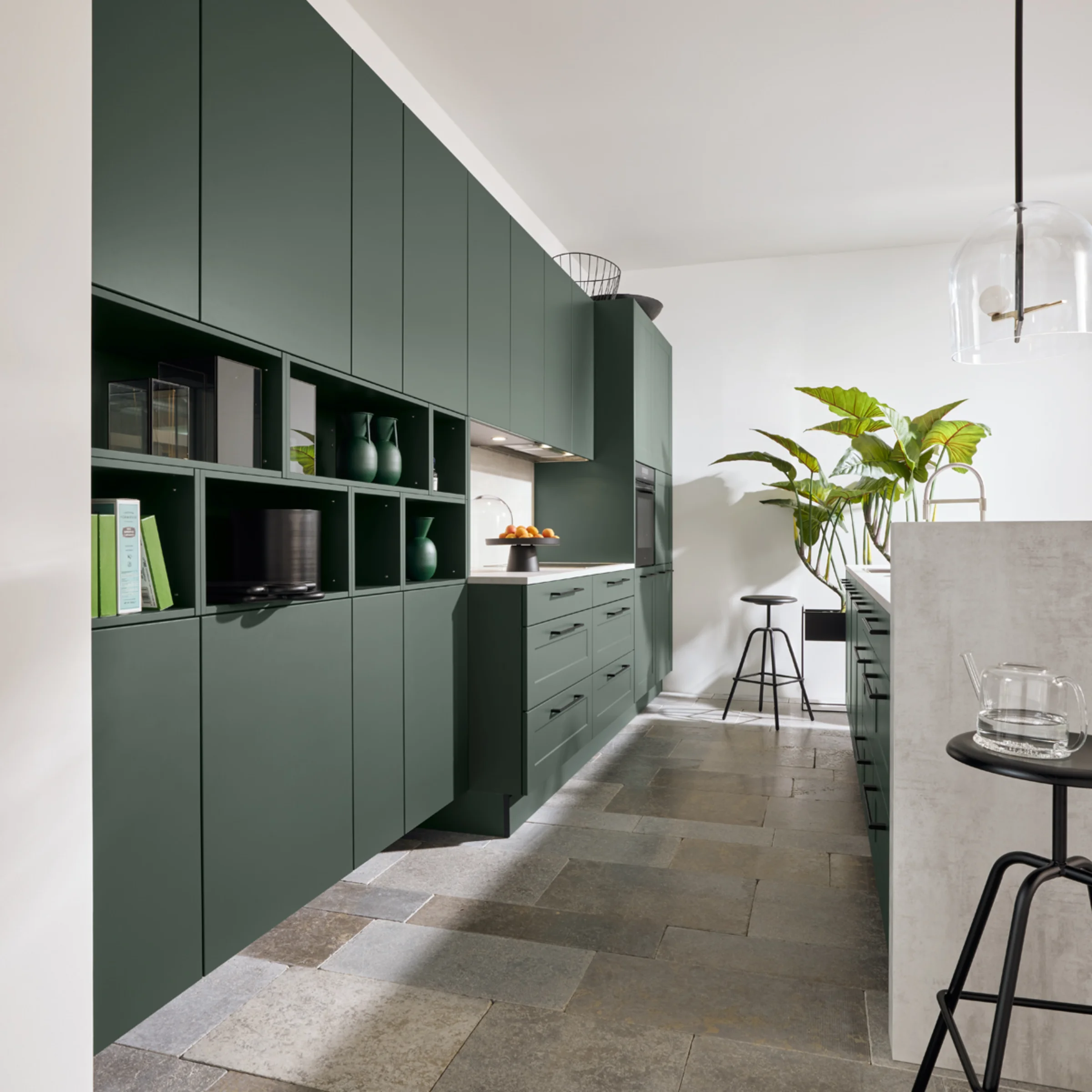 Cucina moderna con armadi verdi e pavimento in pietra, Nolte Kitchen.