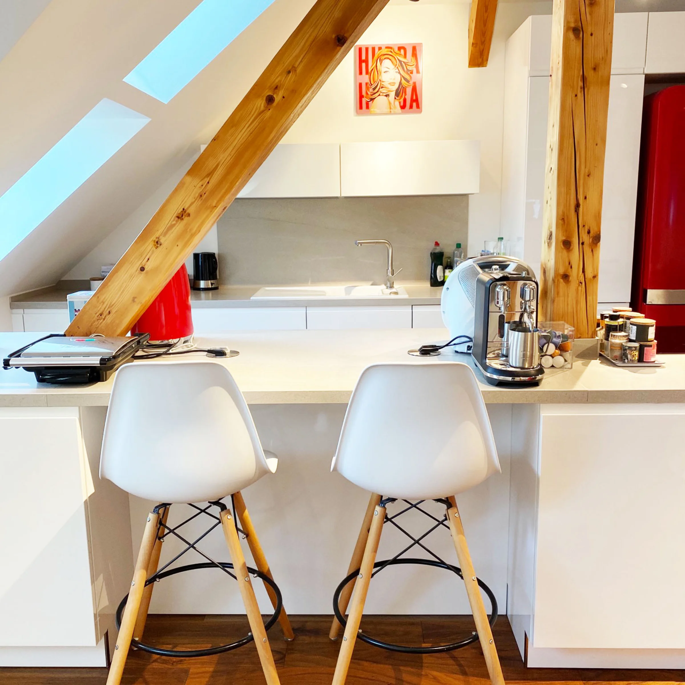 Cucina moderna con armadi bianchi e dettagli in legno, arredata da Nolte Kitchen.