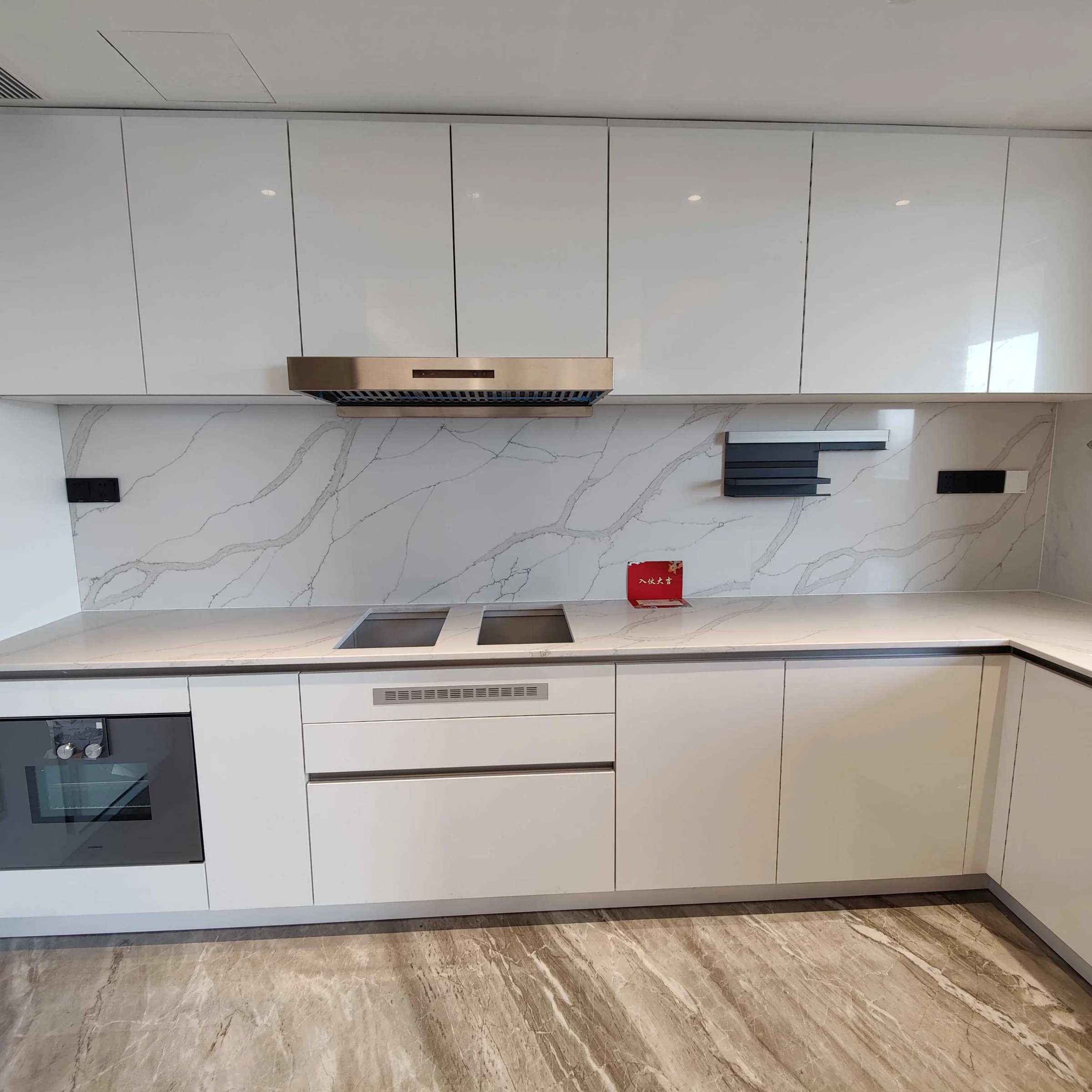 Cucina moderna bianca con piano in marmo e elettrodomestici integrati di Nolte Kitchen.
