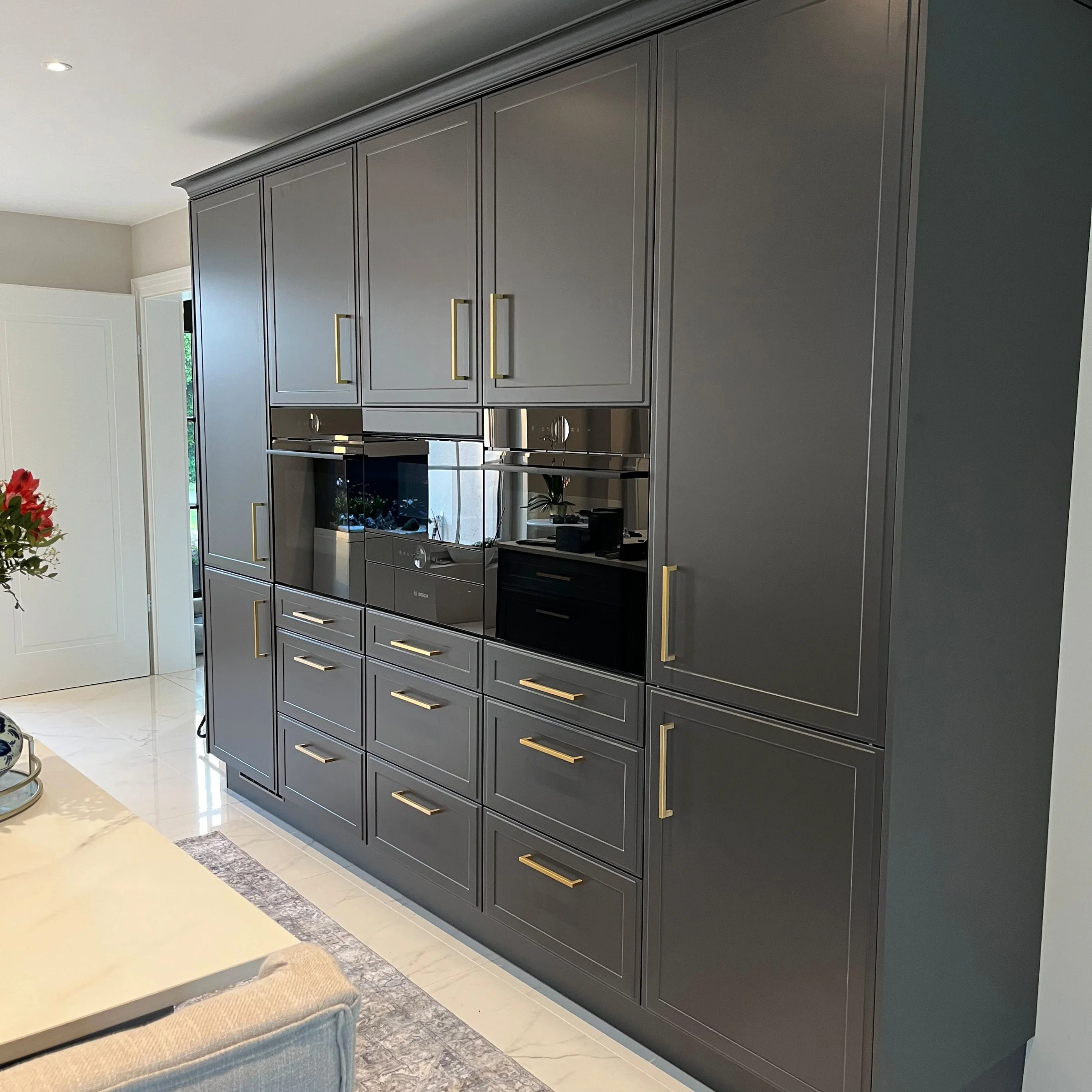 Cucina moderna con armadi grigi e elettrodomestici integrati di Nolte Kitchen.