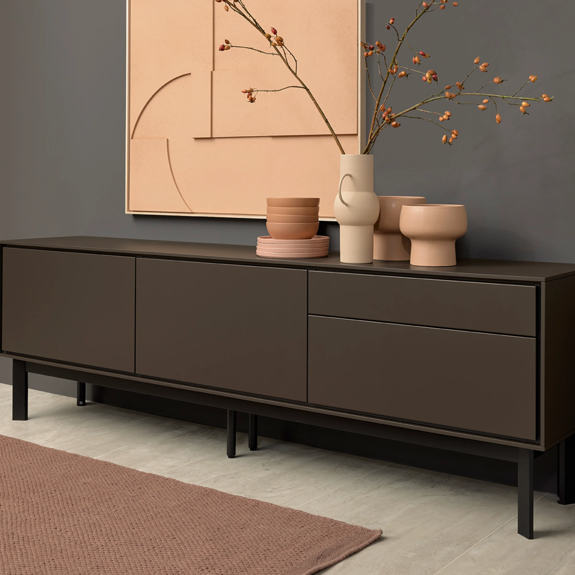 Moderno mobile con decorazioni davanti a parete grigia, in stile Nolte Living.