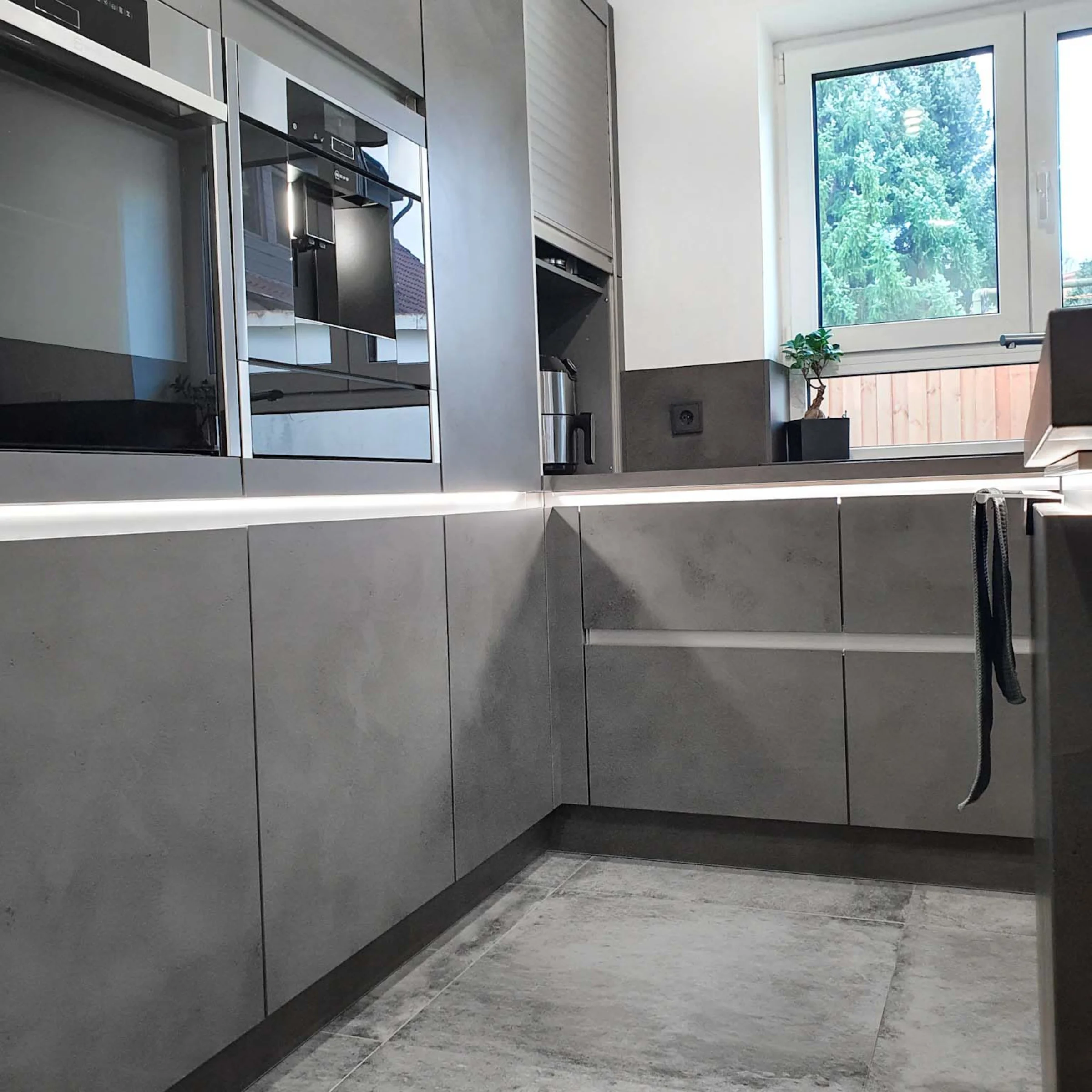 Cucina moderna con armadi grigi e elettrodomestici, Nolte Kitchen.
