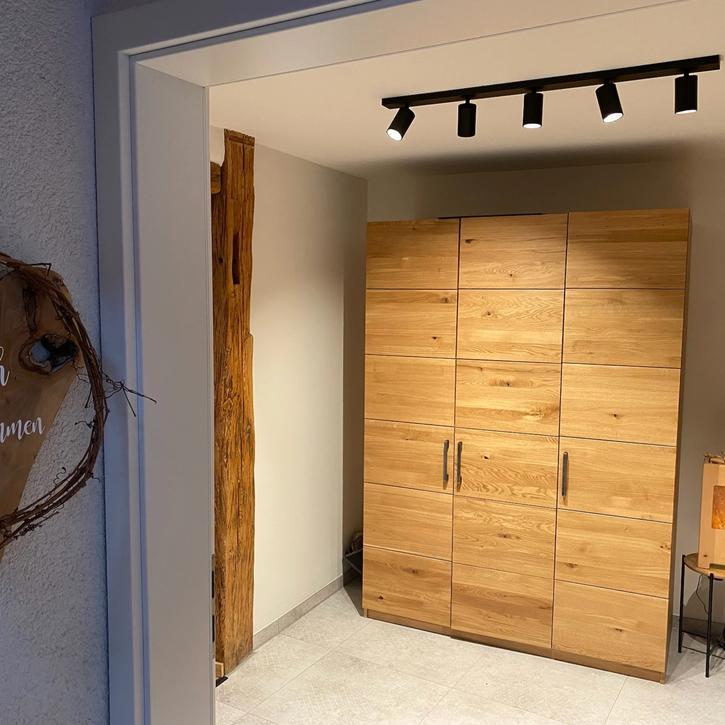Ingresso con armadio in legno e decorazioni, in stile Nolte Living.