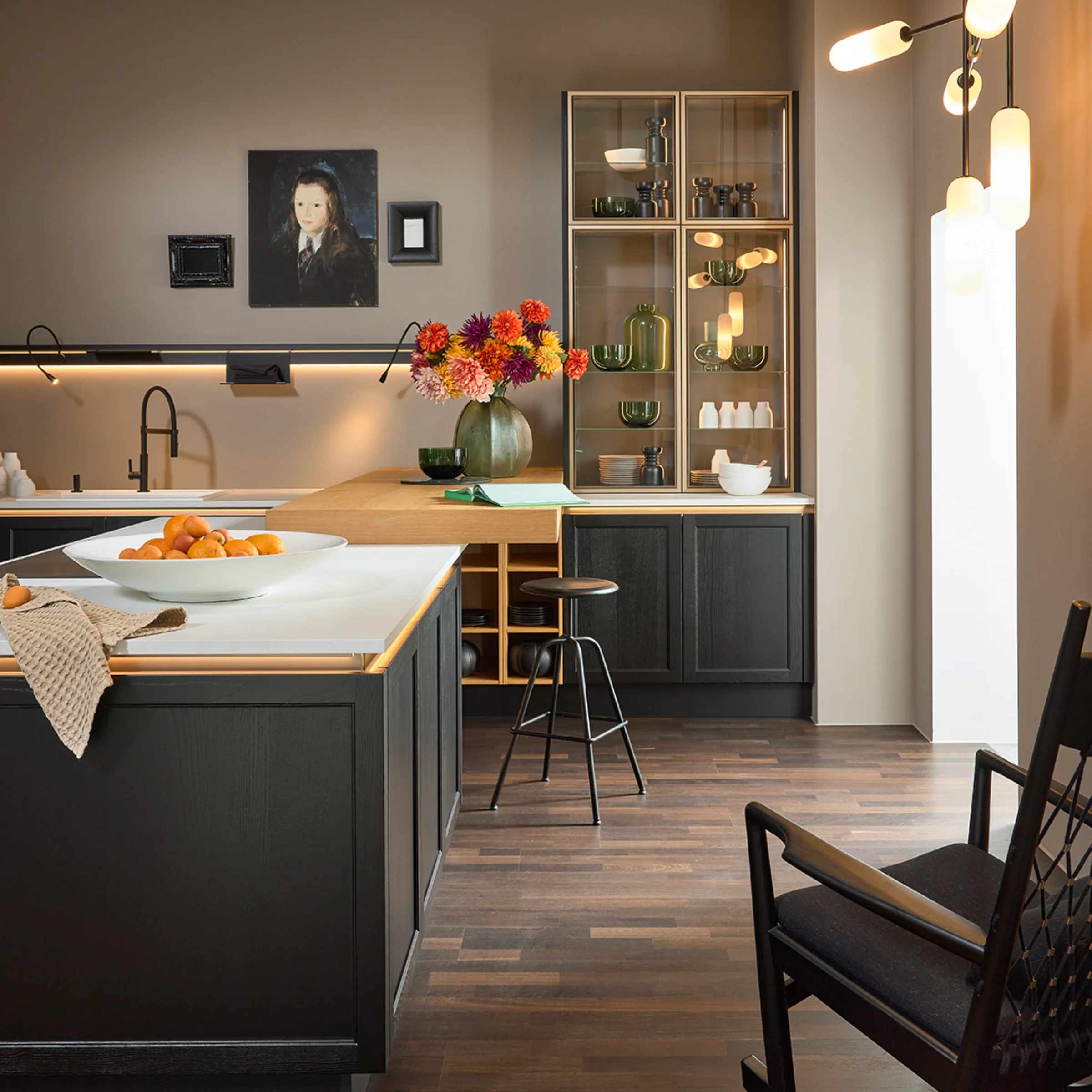 Cucina moderna con armadi scuri e composizione floreale, Nolte Kitchen.