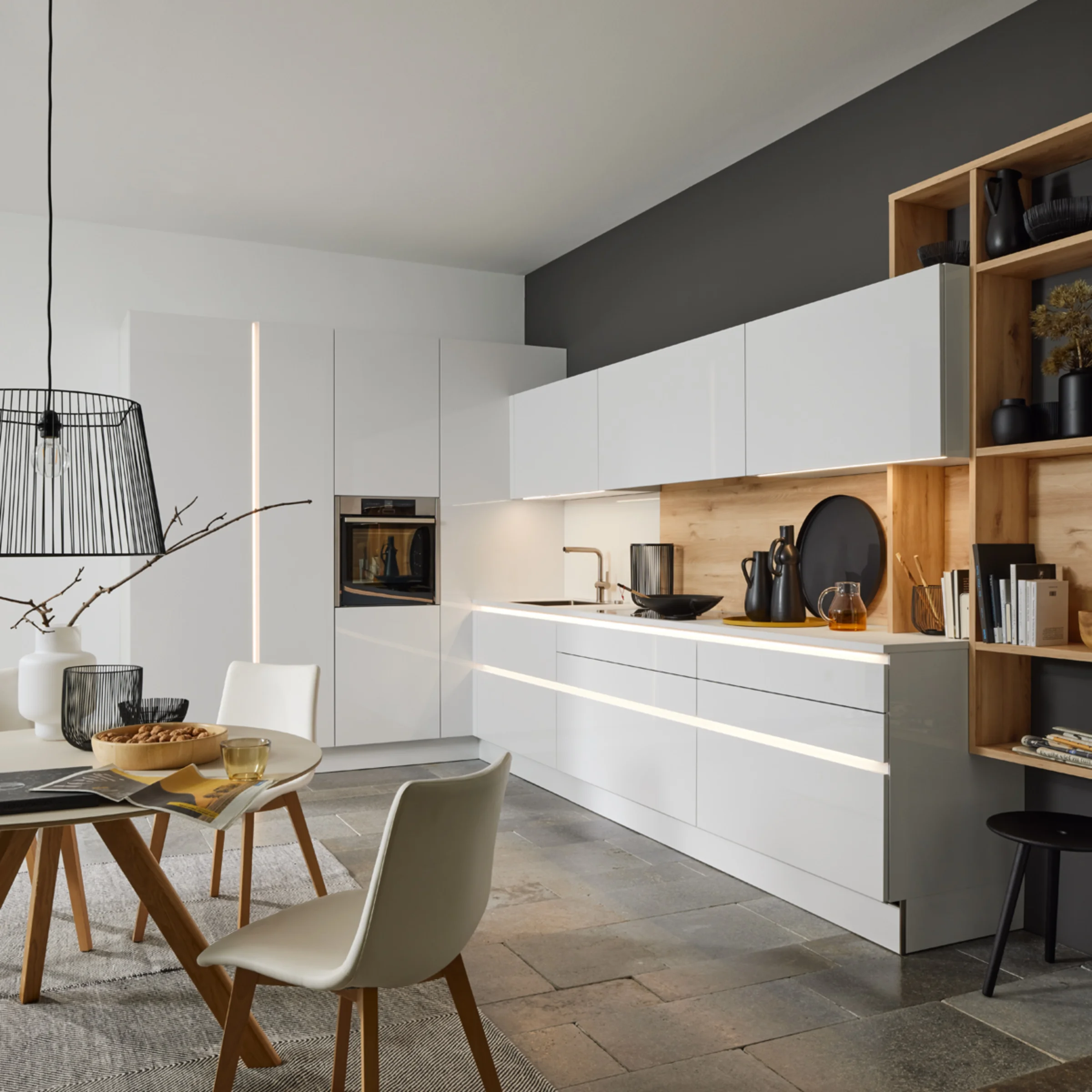 Cucina moderna con armadi bianchi e dettagli in legno, progettata da Nolte Kitchen.