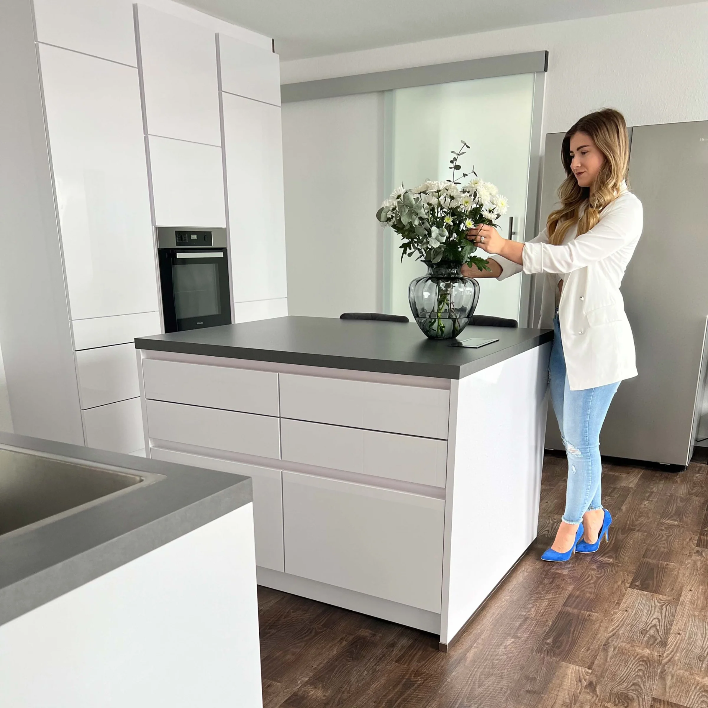 Una donna sistema fiori in una cucina moderna Nolte.