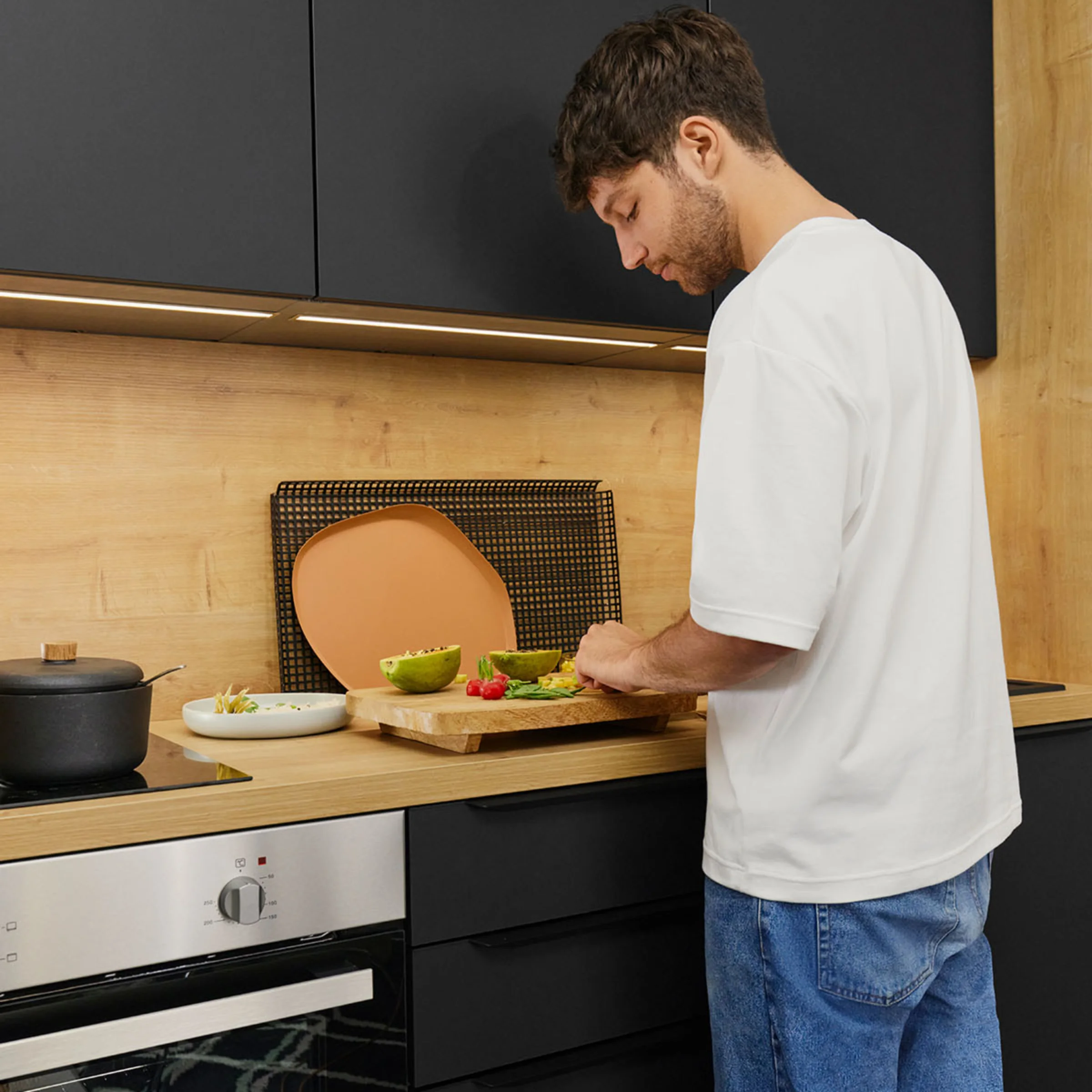 Un uomo prepara ingredienti in una cucina moderna, circondato da cucine Nolte.