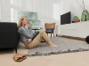 Una donna è seduta con una tazza in un soggiorno moderno con mobili Nolte Living.