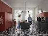 Cucina moderna Nolte con due persone, pavimento geometrico e armadi rossi.