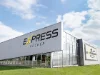 Un bâtiment moderne avec l'inscription "Express Küchen" sous un ciel bleu.
