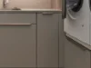 Moderna lavanderia con armadi grigi e lavatrice, Nolte Utility Rooms.