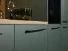 Armadi da cucina moderni con frontali verdi e maniglie nere di Nolte Kitchen.