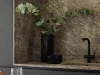 Cucina elegante con effetto marmo e rubinetto nero, arricchita da piante verdi. Nolte Kitchen.
