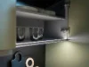 Un armadietto da cucina aperto con piatti e bicchieri, illuminato dall'interno. Nolte Kitchen.