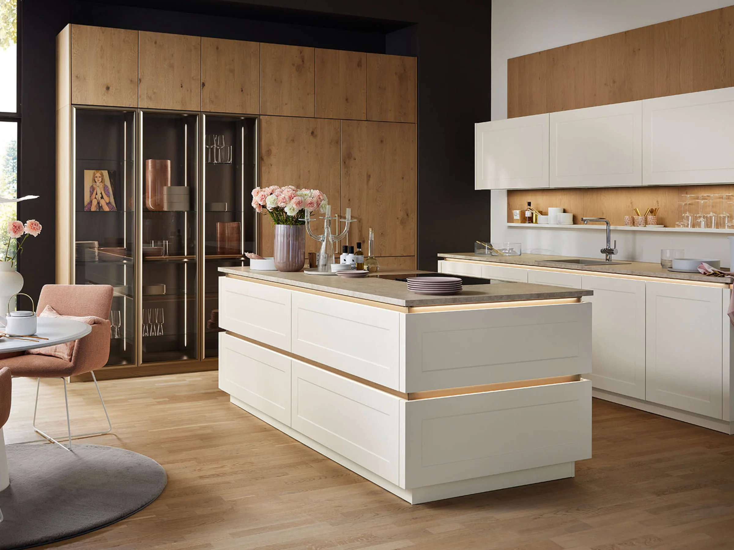 Cucina moderna con isola e dettagli in legno, decorata con fiori. Nolte Kitchen.