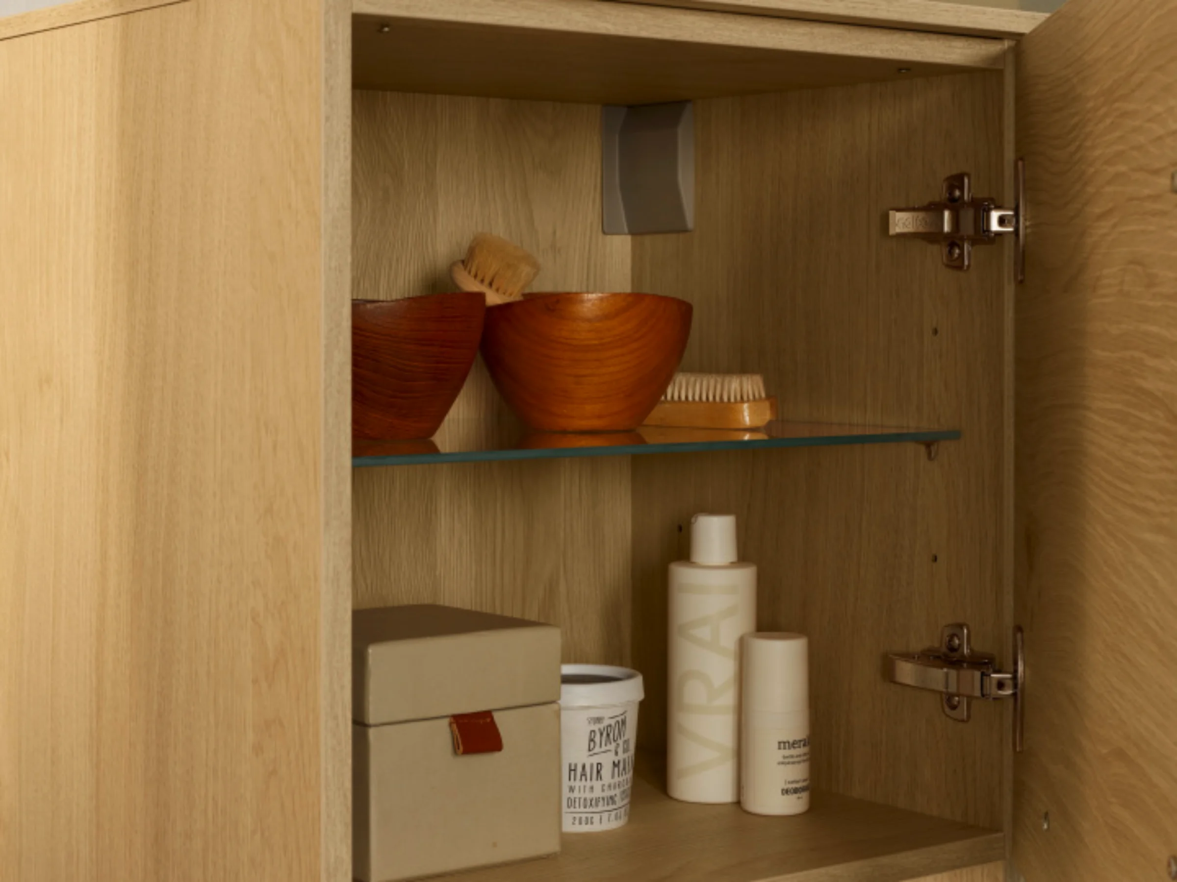 Un armadietto da bagno aperto con prodotti per la cura e asciugamani, Nolte SPA.