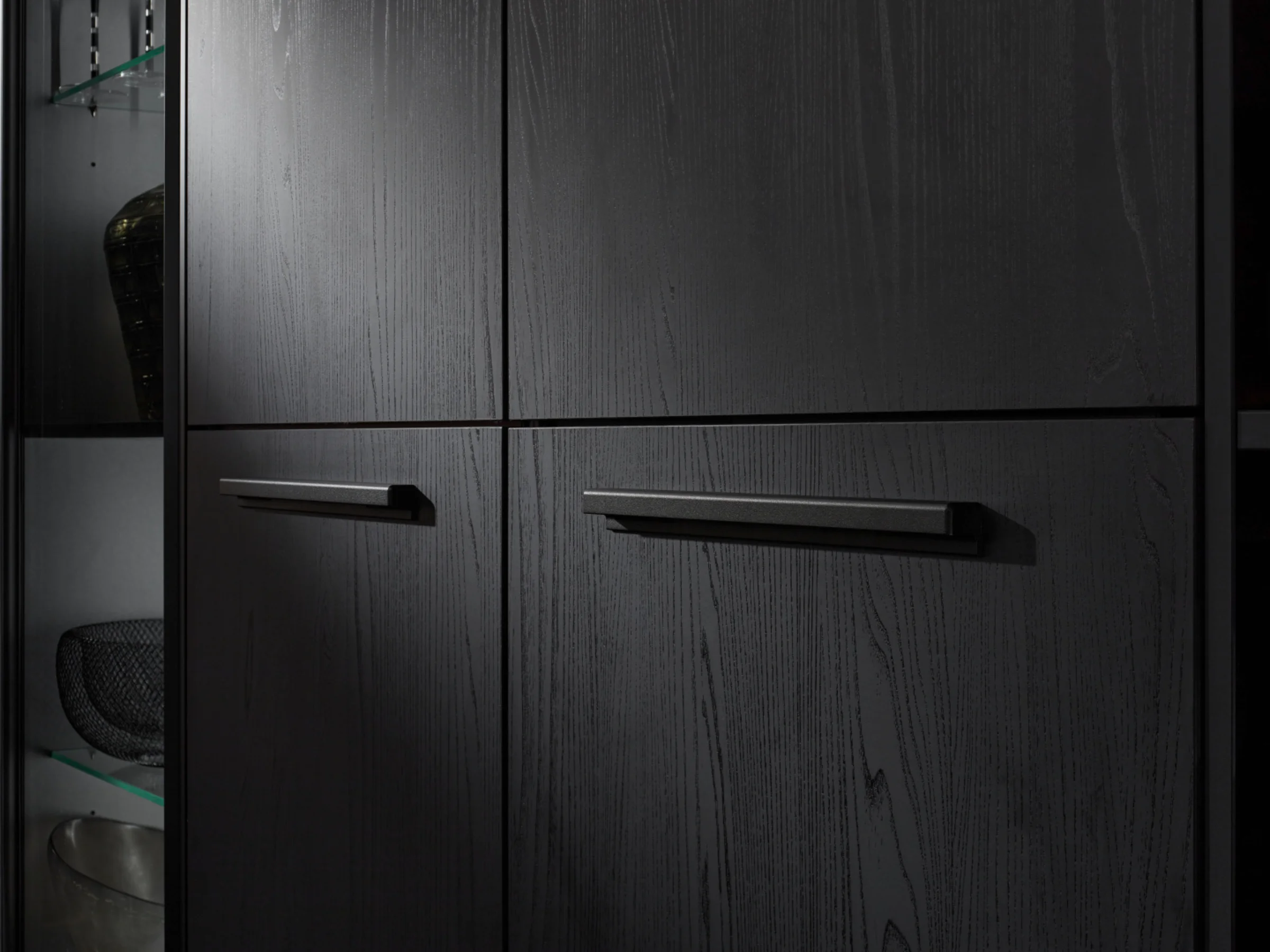 Frontale di un armadio nero con maniglie moderne, parte di Nolte Living.