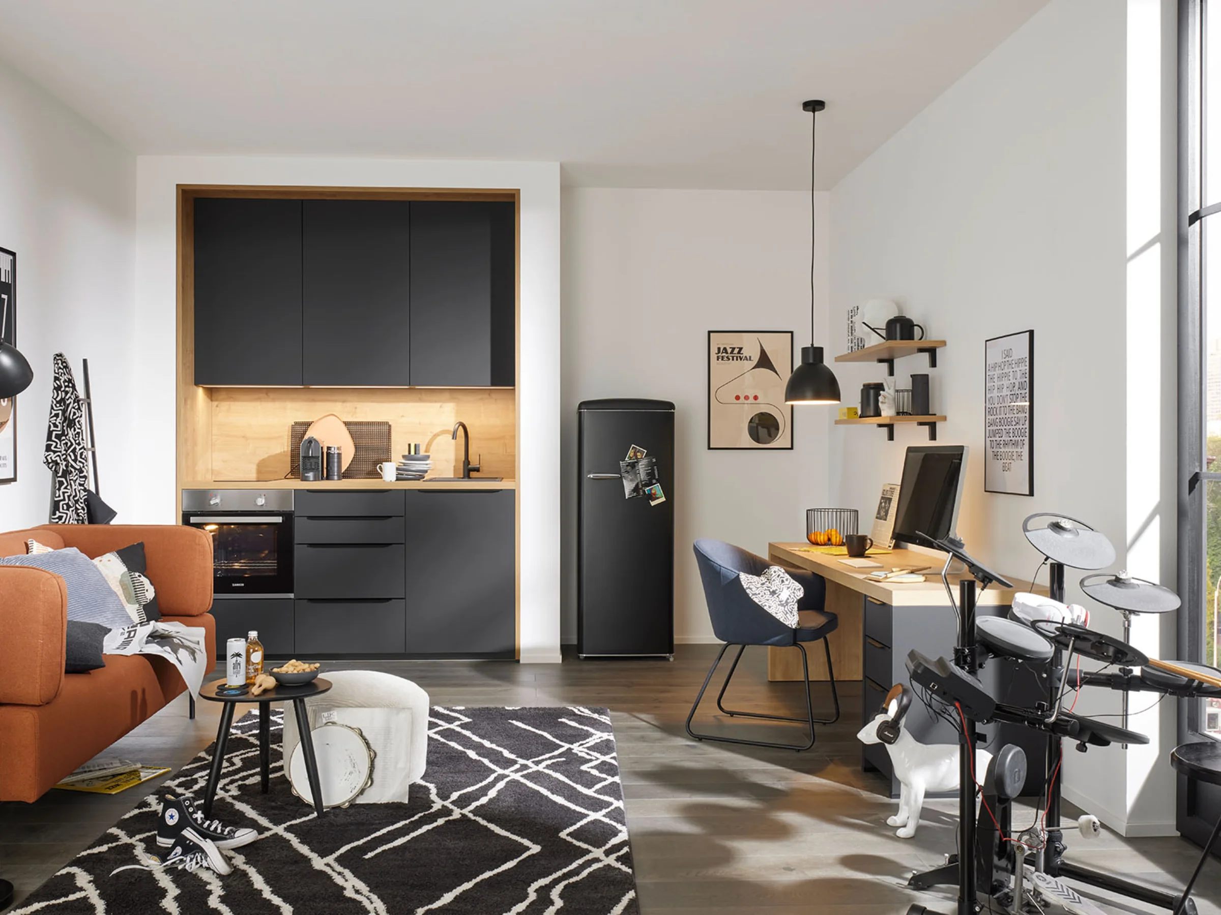 Cucina moderna con armadi neri e un'accogliente area soggiorno di Nolte Kitchen.