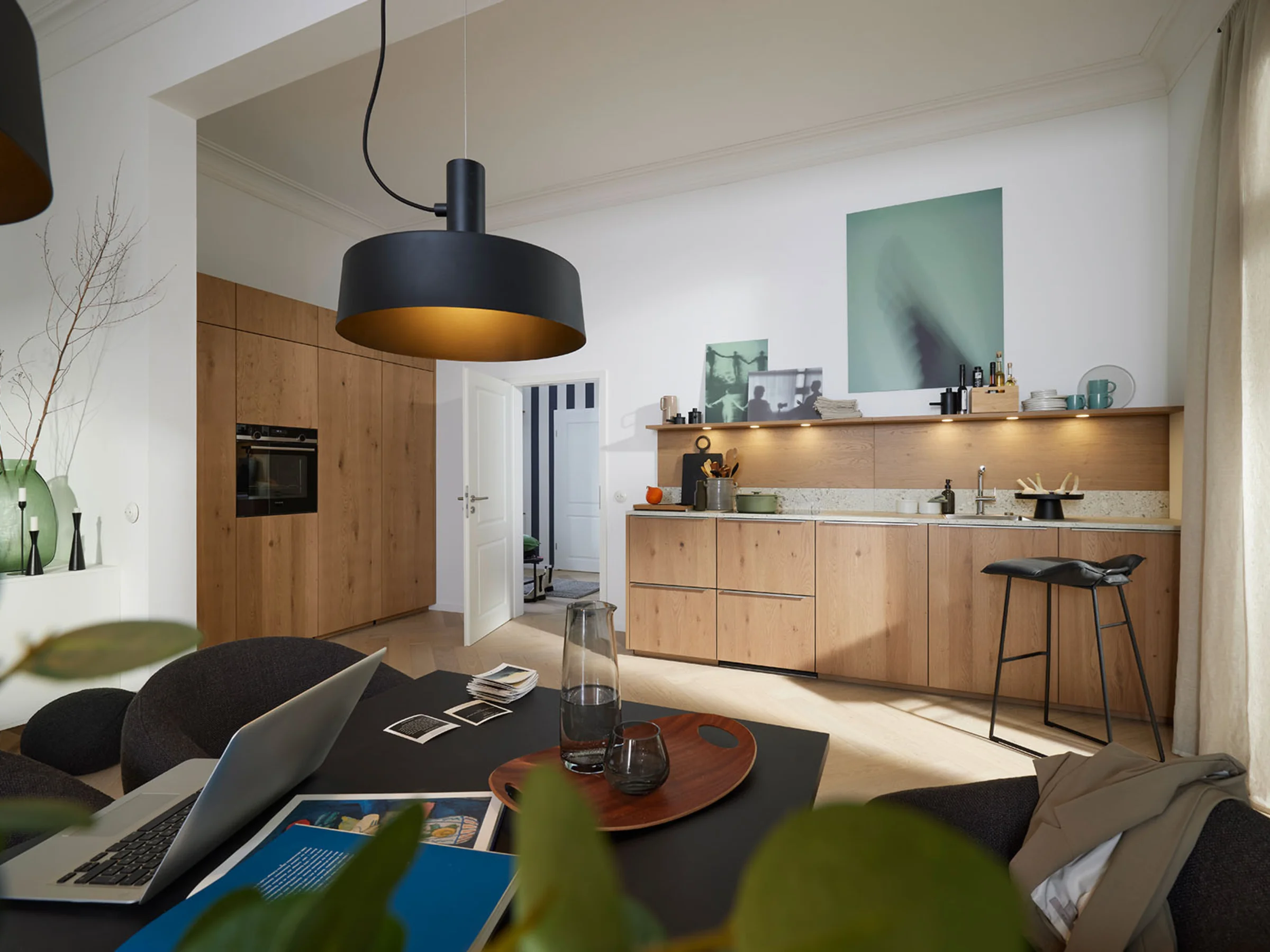 Cucina moderna con armadi in legno e isola in uno spazio aperto. Nolte Kitchen.