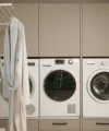 Locale lavanderia con lavatrice, asciugatrice e armadi; Nolte Utility Rooms.