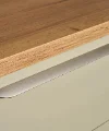 Tiroir de cuisine vert avec plan de travail en bois et poignée en métal, Express Küchen.