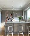 Una donna è seduta su un'isola cucina moderna con fiori, Nolte Kitchen.