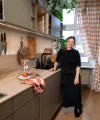 In una moderna cucina Nolte, una donna è al bancone con un tagliere e bicchieri.