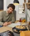 Un uomo lavora a una scrivania in una cucina moderna di Nolte Kitchen.