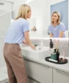 Una donna si lava le mani in un moderno bagno, Nolte SPA.