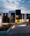 Edificio moderno del Nolte Forum al crepuscolo, circondato da sentieri illuminati e aree verdi.