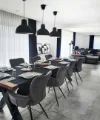 Sala da pranzo elegante con tavolo lungo e lampade moderne di Nolte Living.